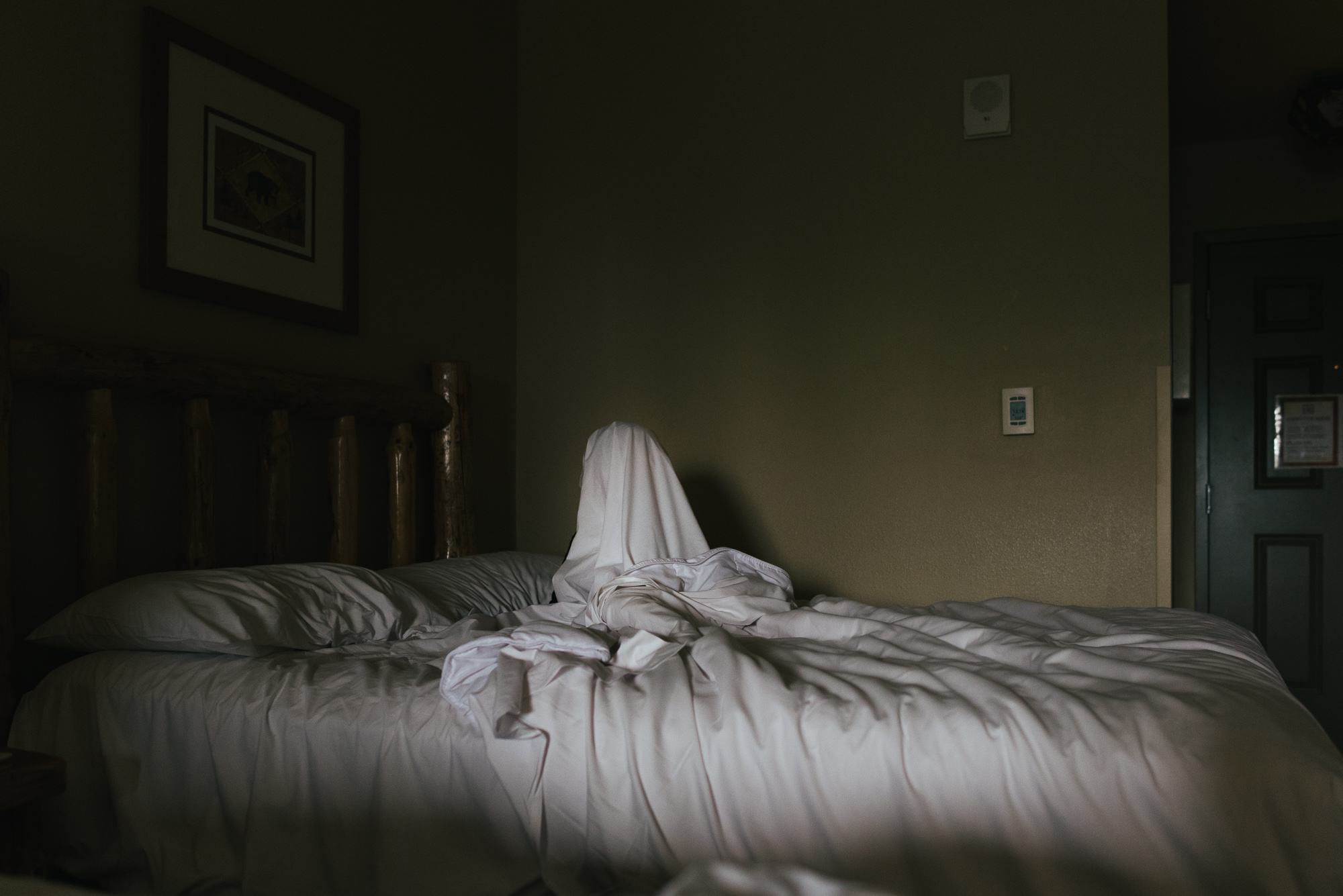 kid hiding under bedsheet - documentary family photography