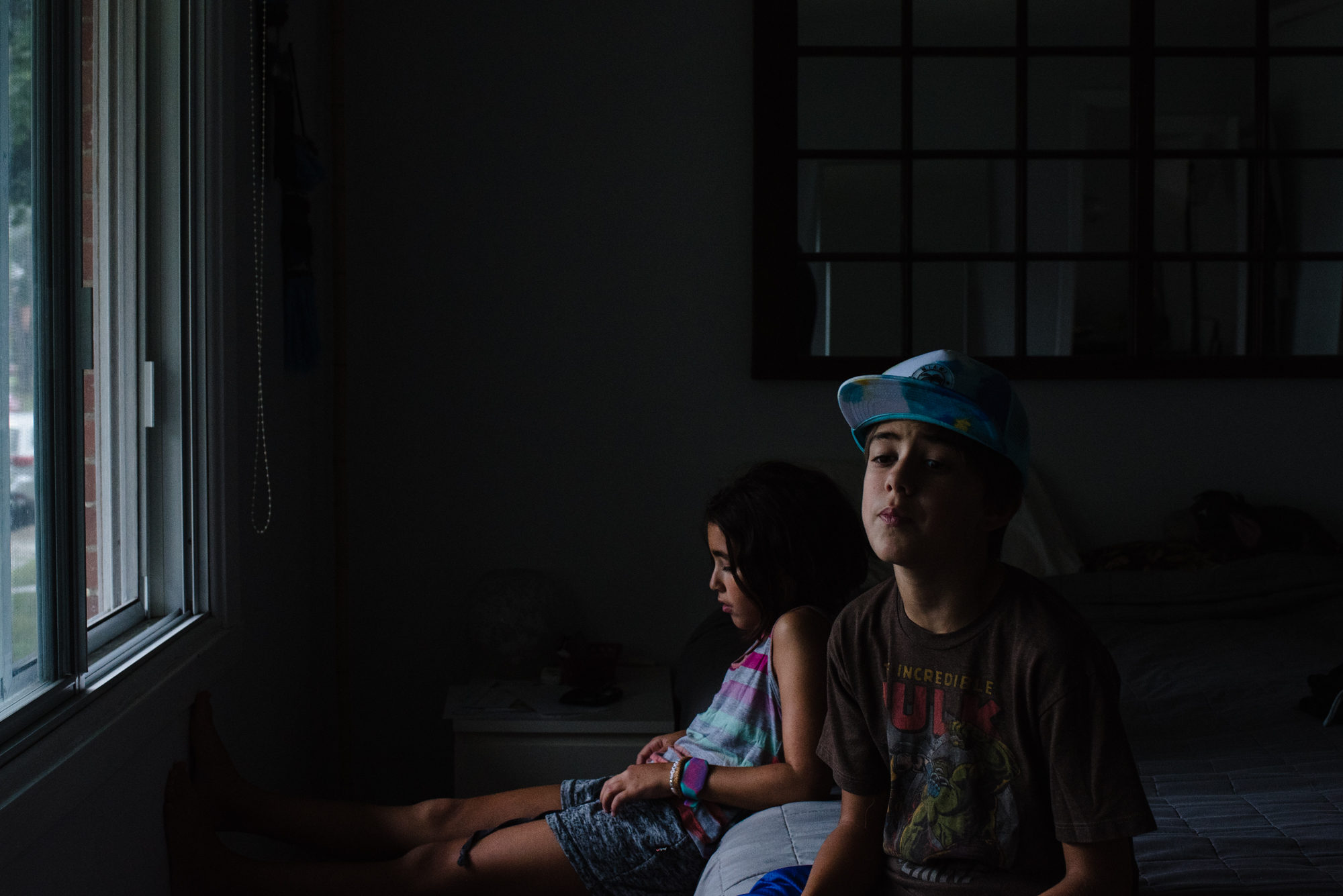 kids look bored in dark room - documentary family photography