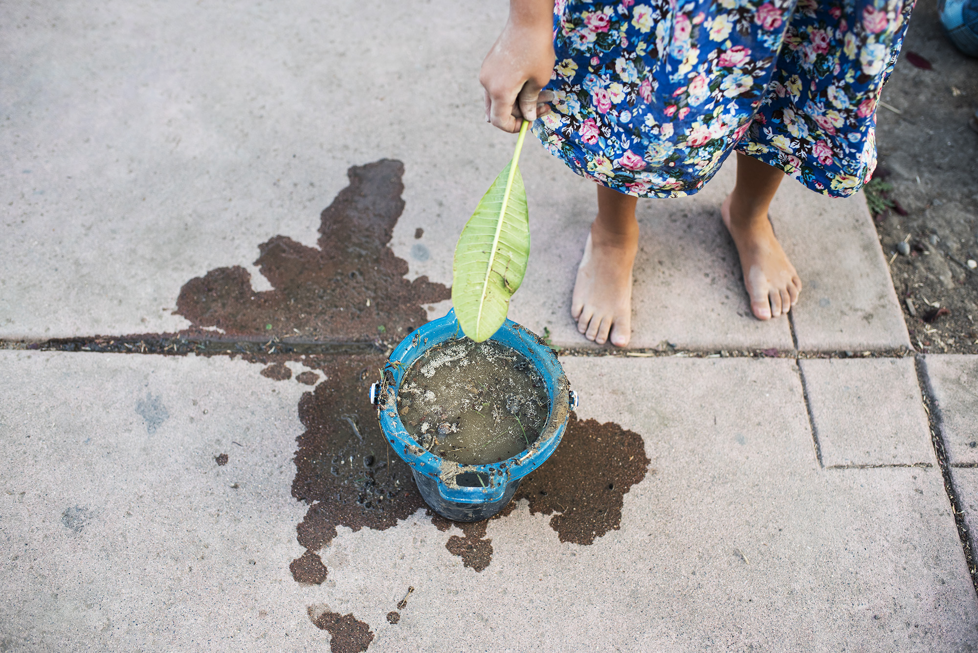 kid with leaf and bucket - documentary family photography