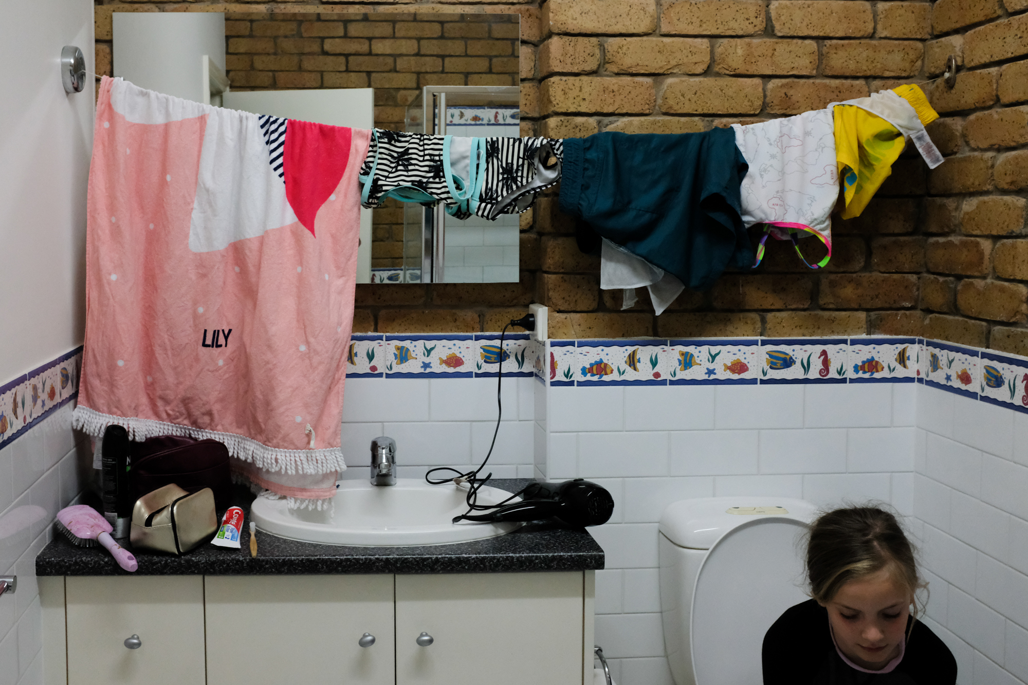 line dry laundry in bathroom - documentary family photography