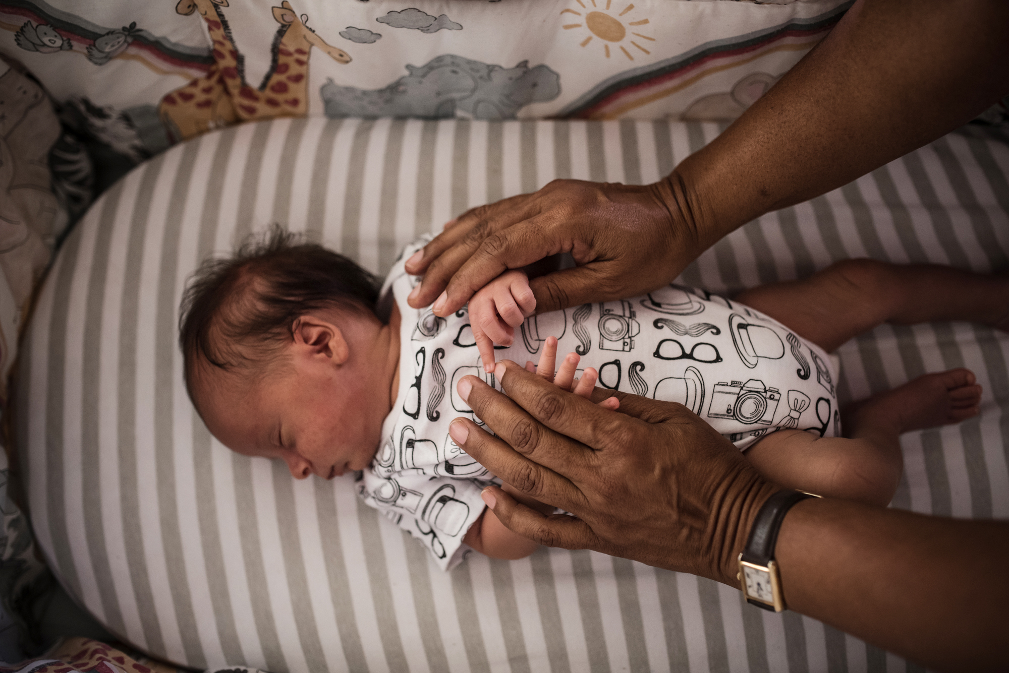 Father holding baby hands - documentary family photography