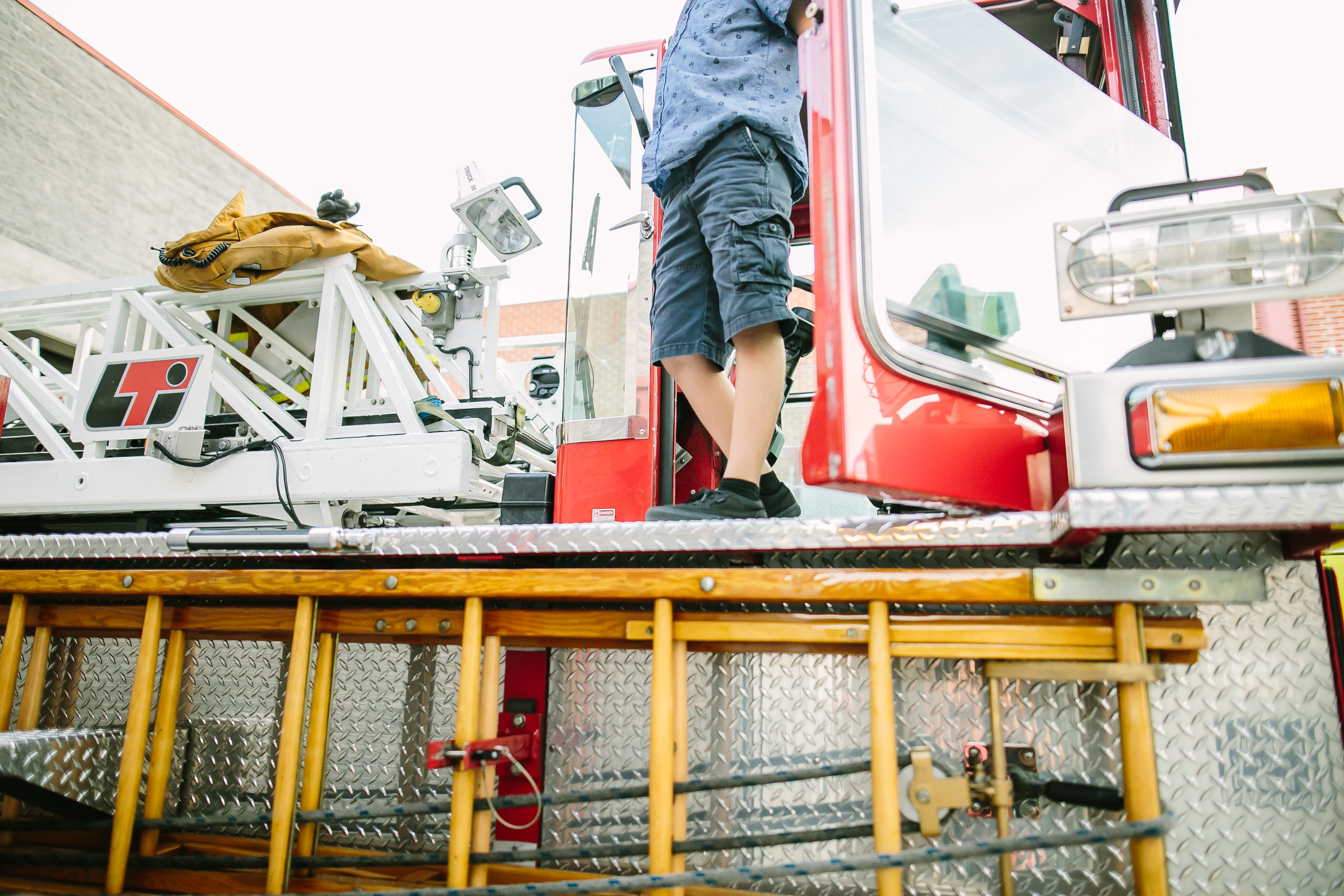 boy stepping out of fire truck - documentary family photography