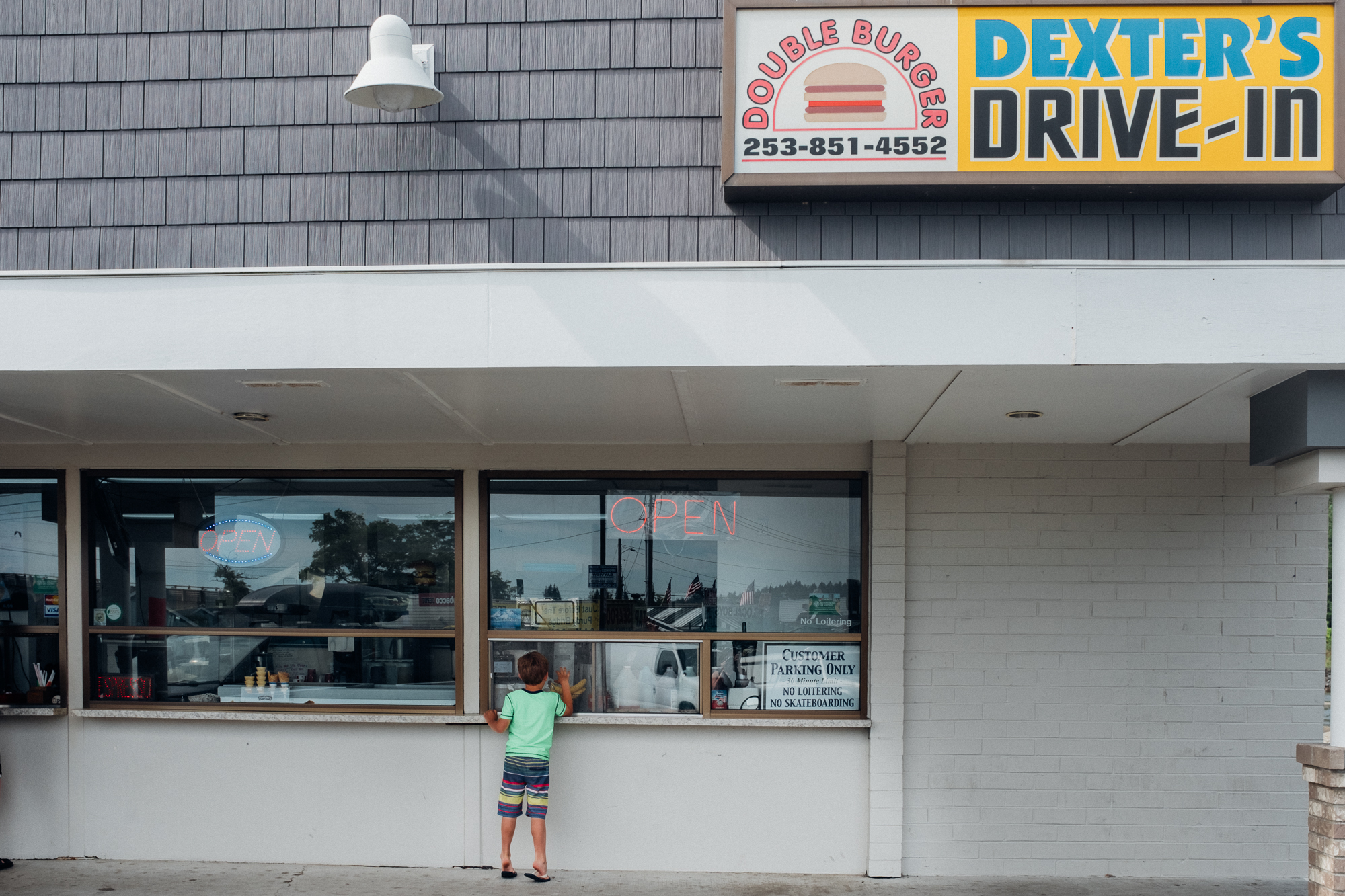 Boy at burger take out window - documentary family photography