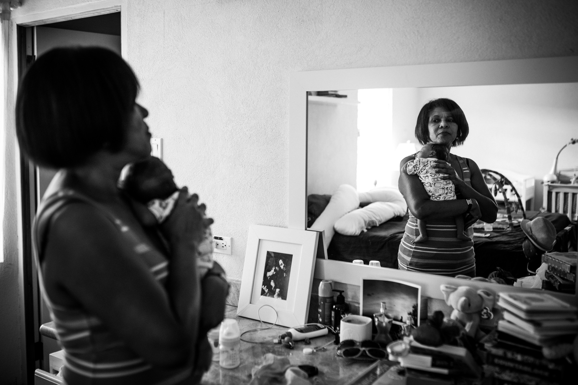 woman holding baby in mirror - documentary family photography