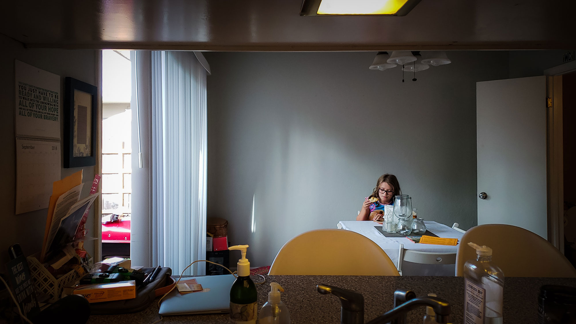 girl at table by herself - documentary family photography