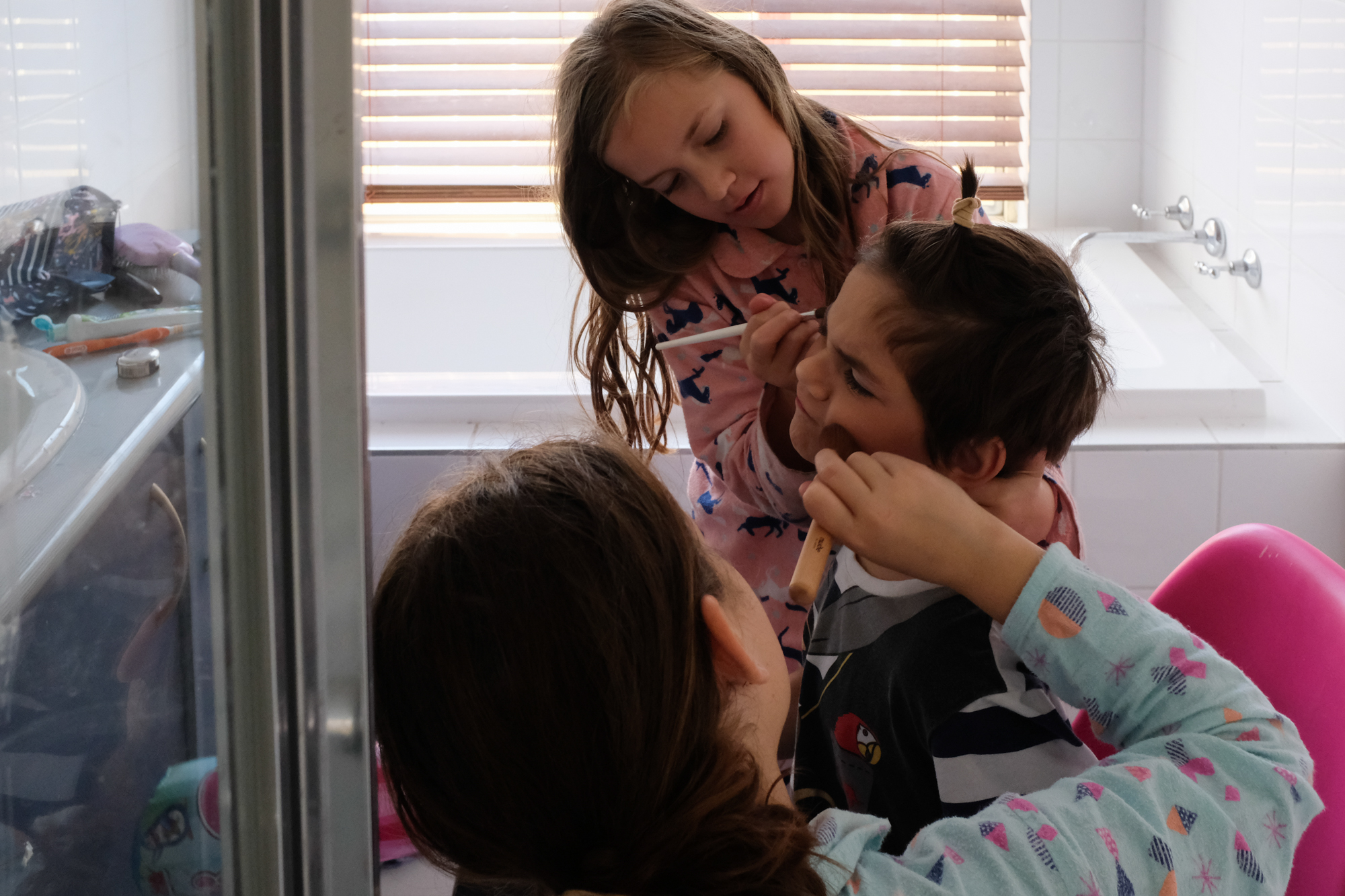 girl putting makeup on brother - documentary family photography