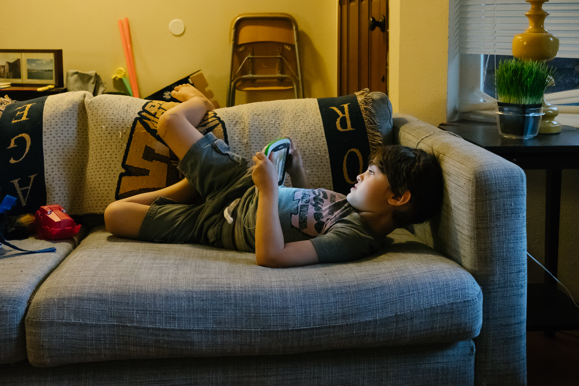boy plays on tablet - documentary family photography