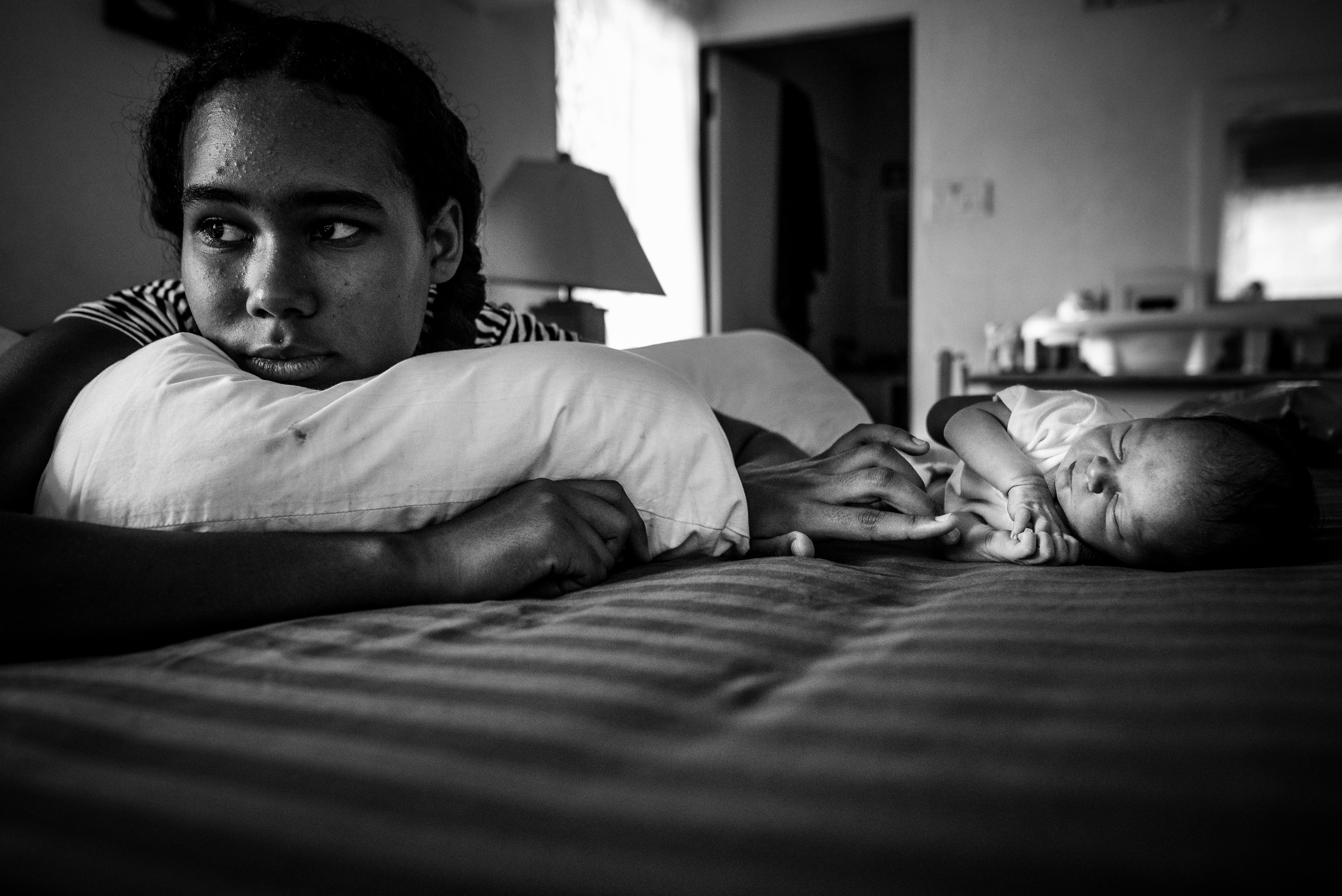 girl on bed wth baby - documentary family photography