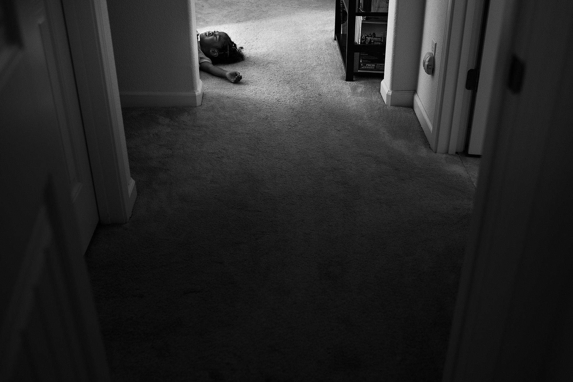 kid laying in the middle of a doorway - documentary family photography