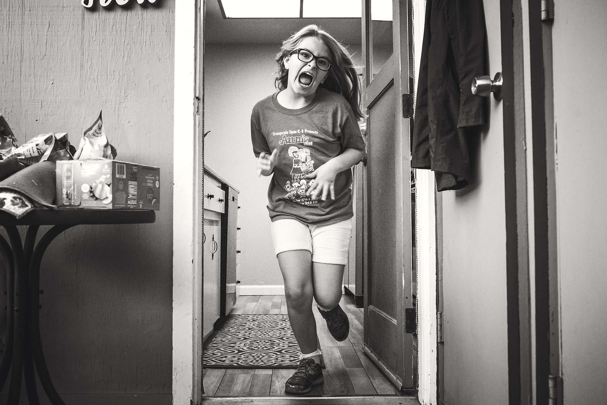 girl running through doorway - documentary family photography