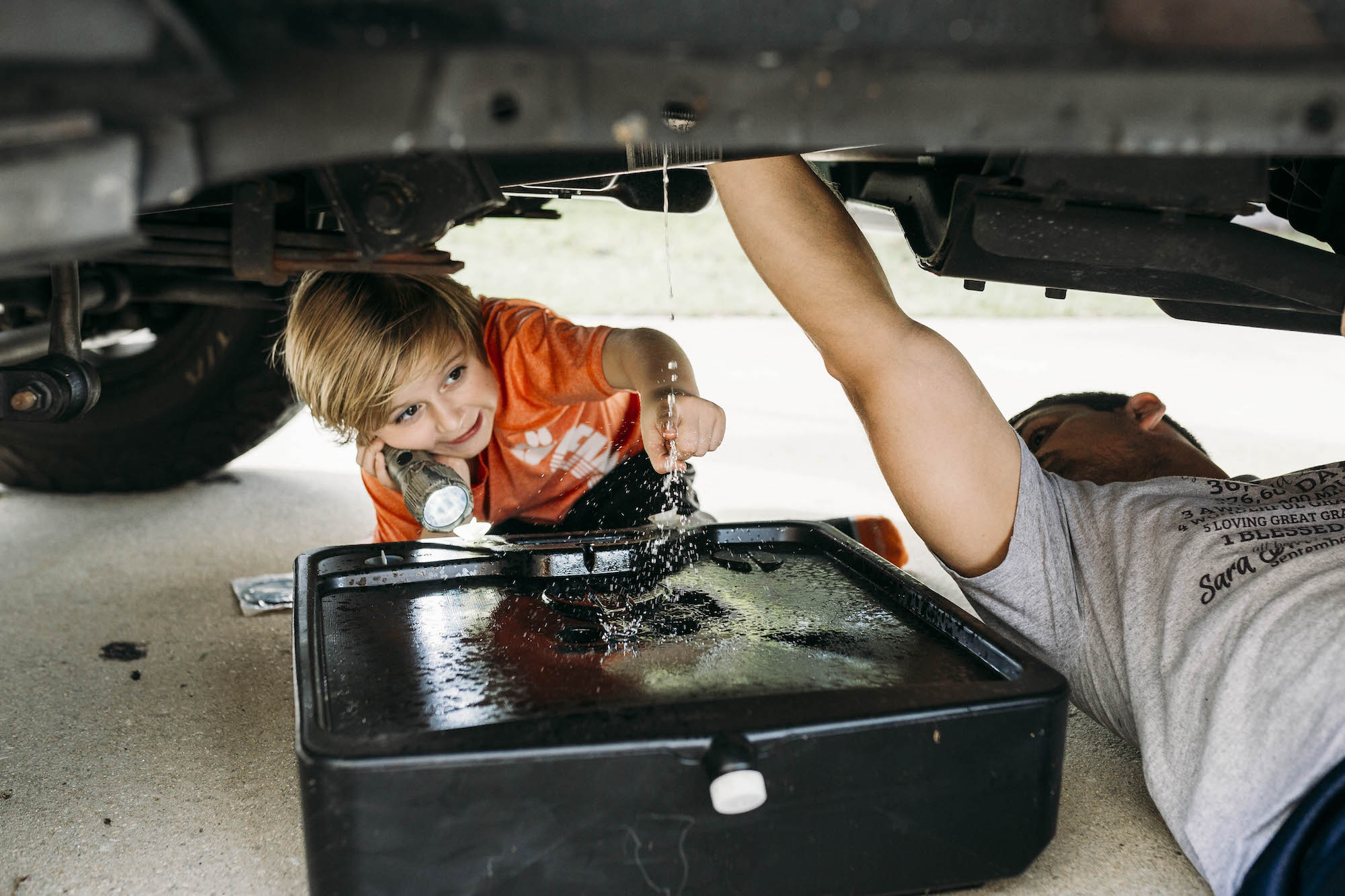 boy with dad and oil pan - documentary family photography