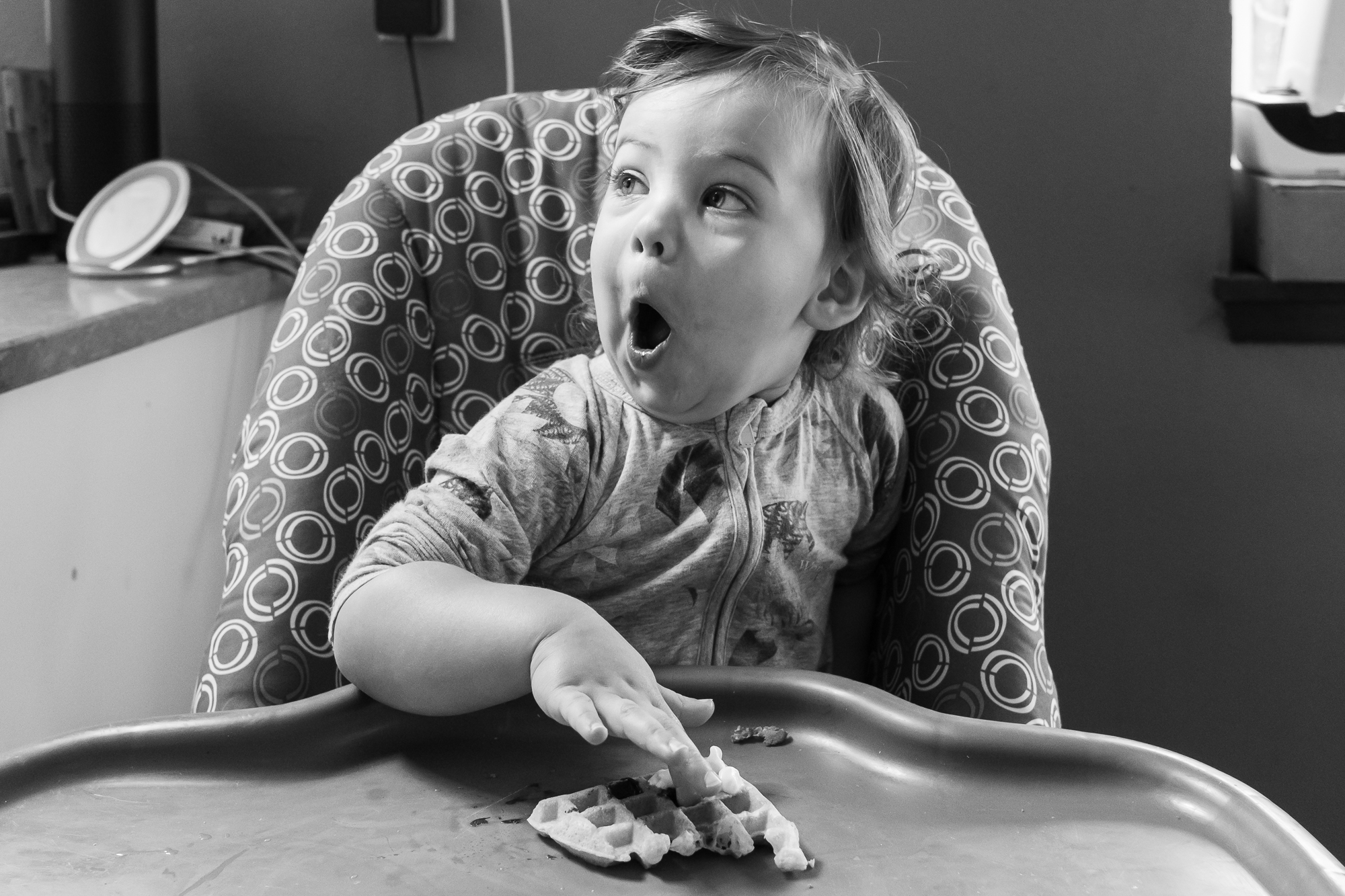 girl makes face in high chair - documentary family photography