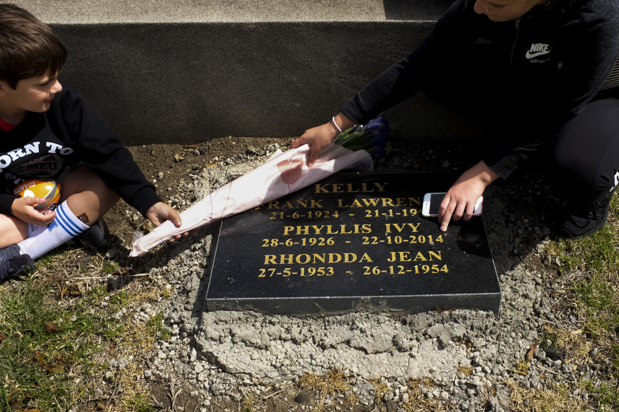 laying flowers on grave - documentary family photography