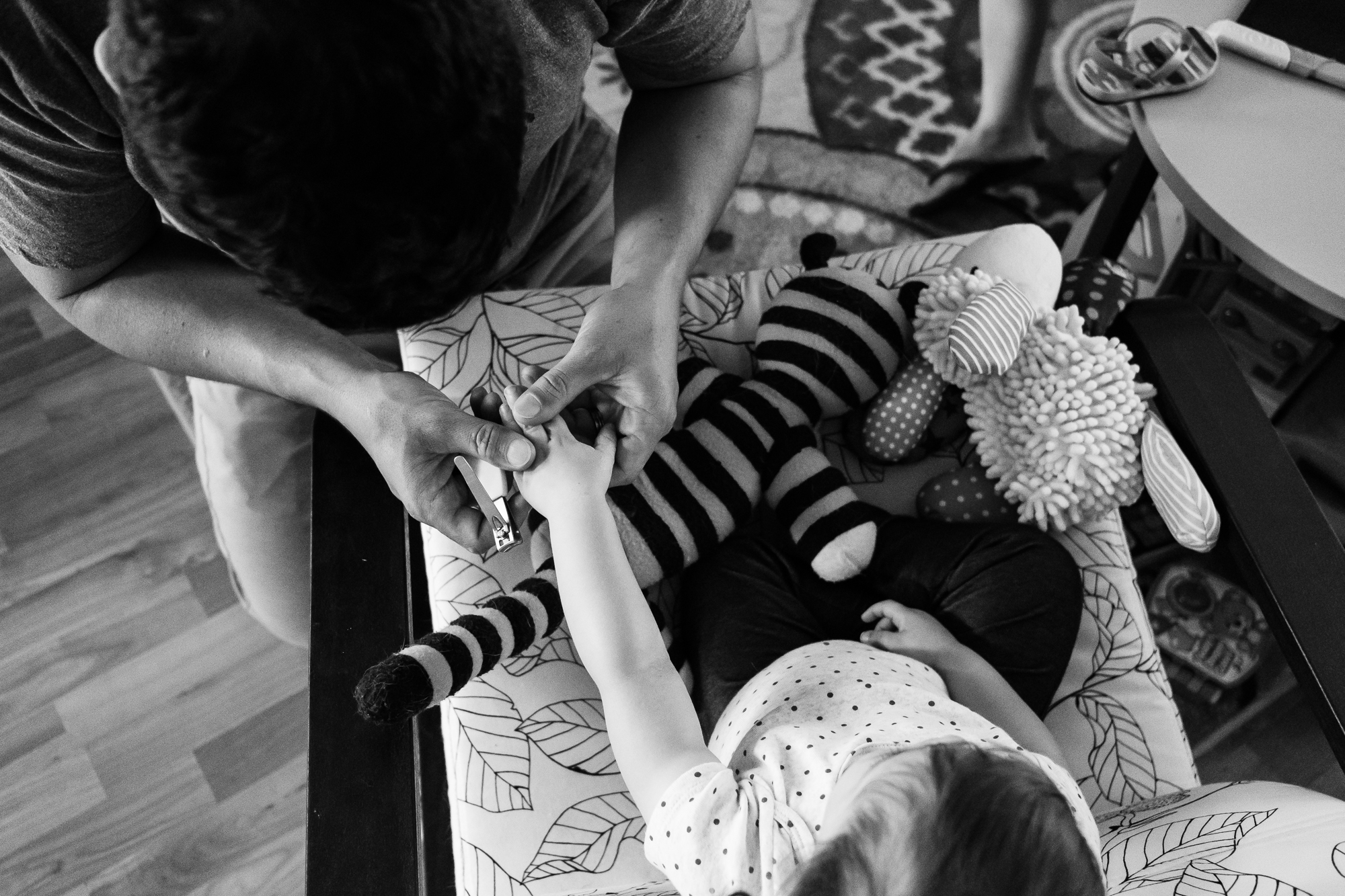 father clipping toddler nails - documentary family photography