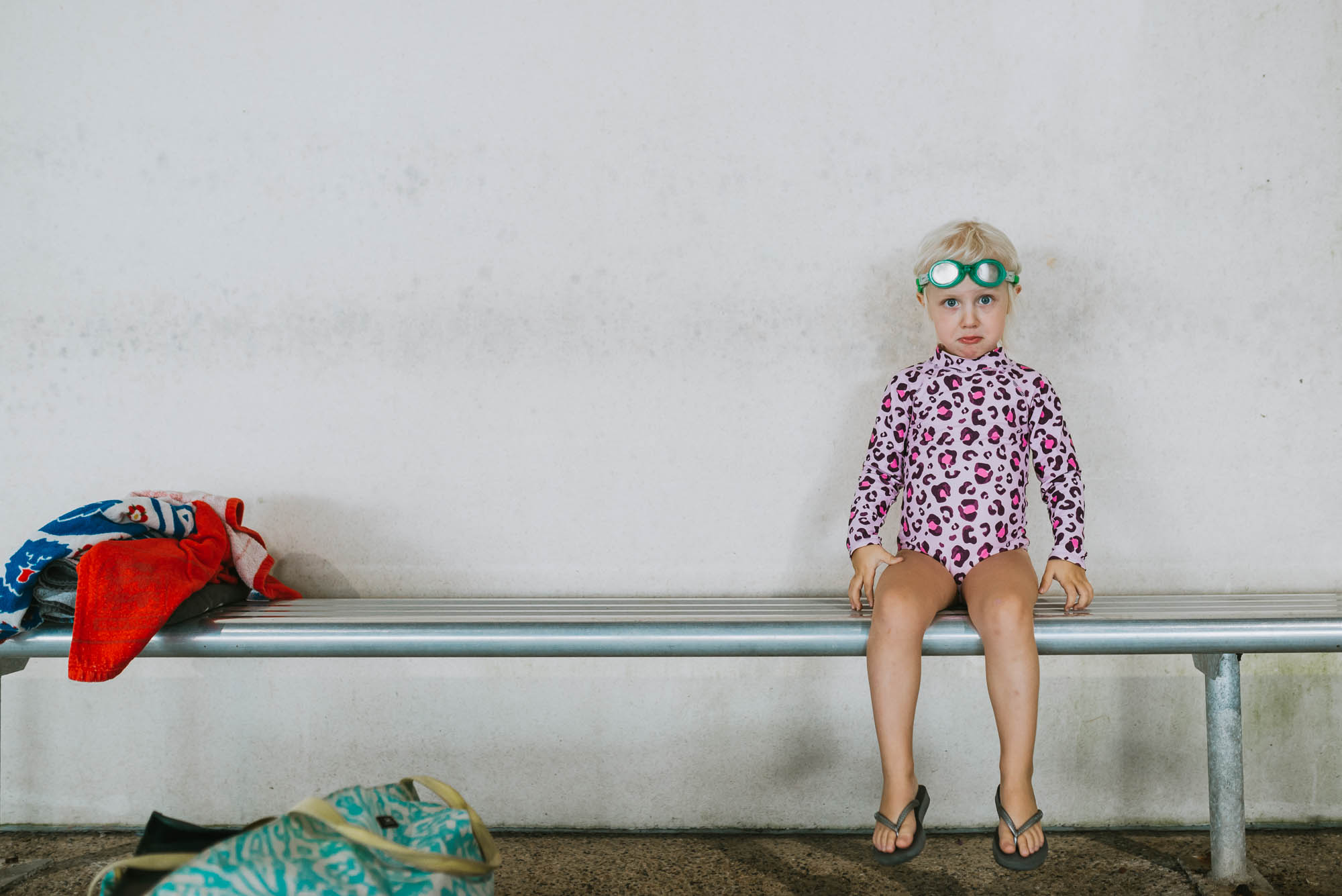 kid sitting on pool bleachers - documentary family photography