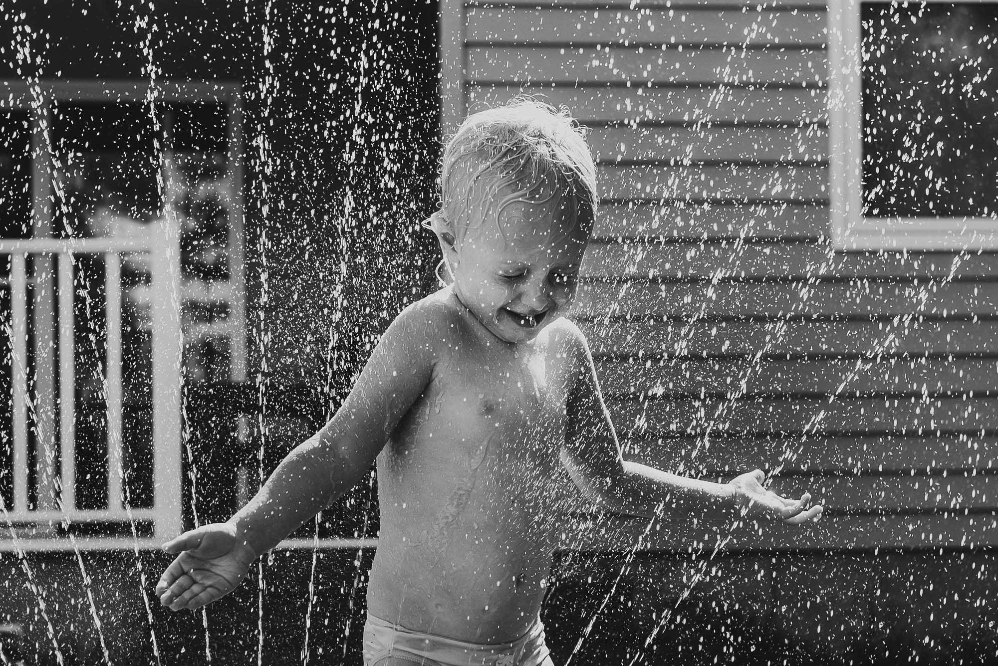 kid in sprinkler - documentary family photography