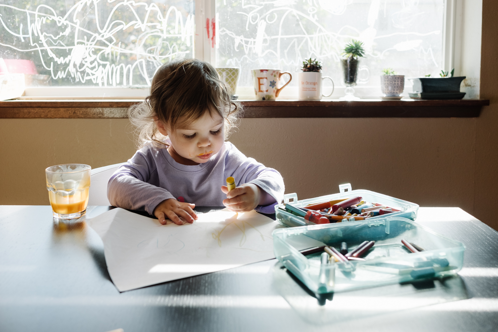 girl colors at kitchen table - documentary family photography