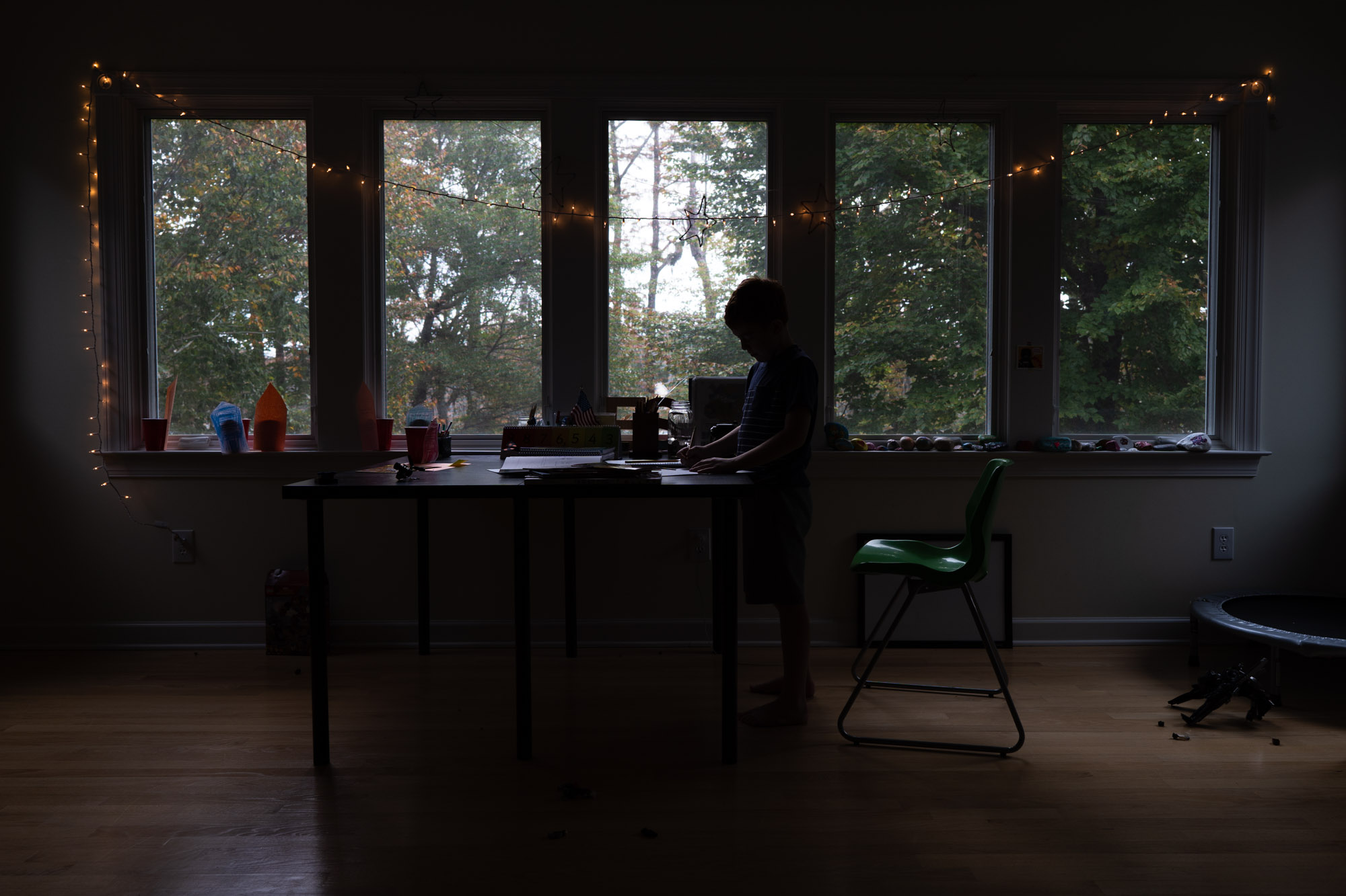 boy in front of window in low light- documentary family photography