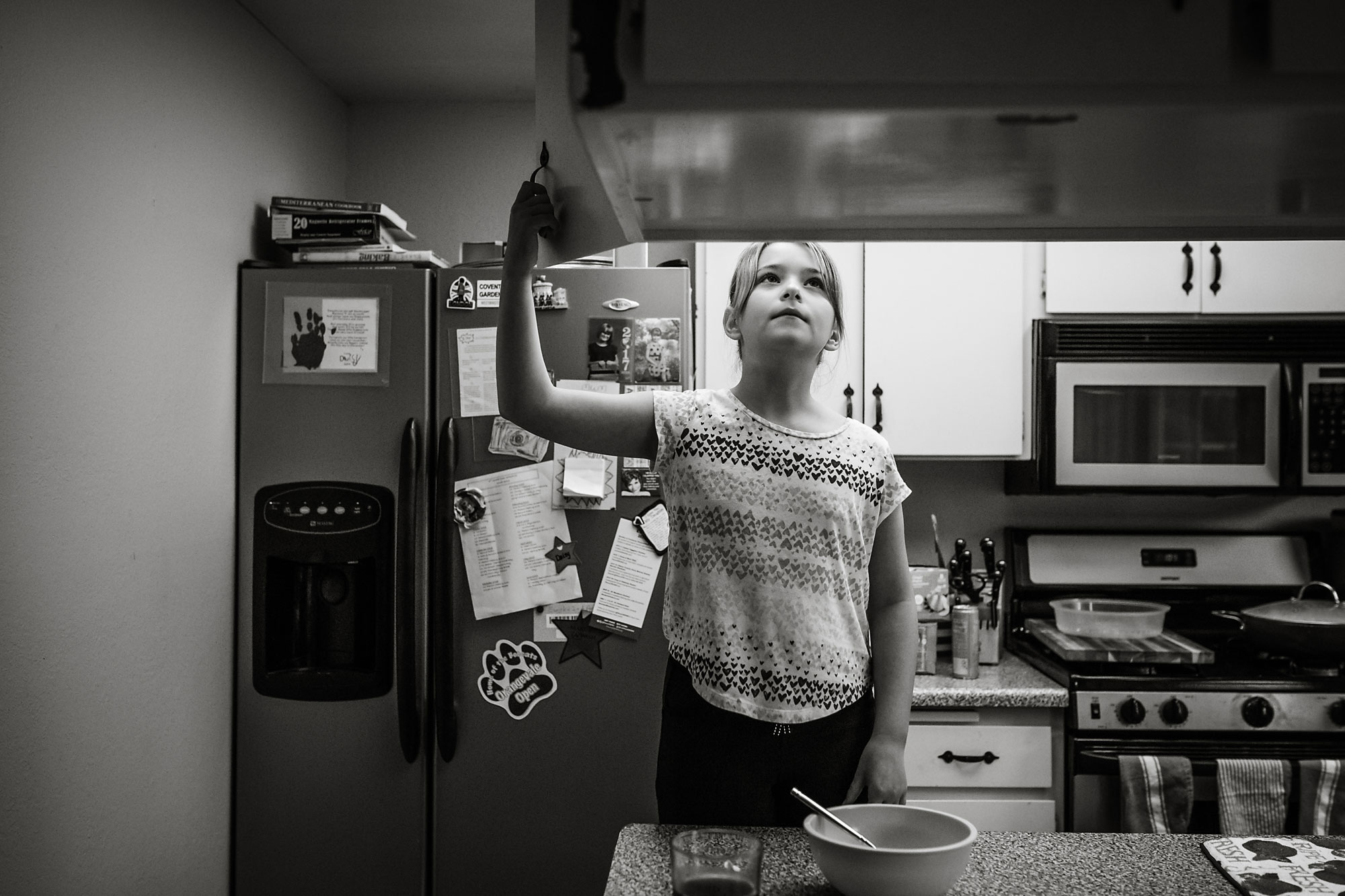 girl looking in cabinets - documentary family photography