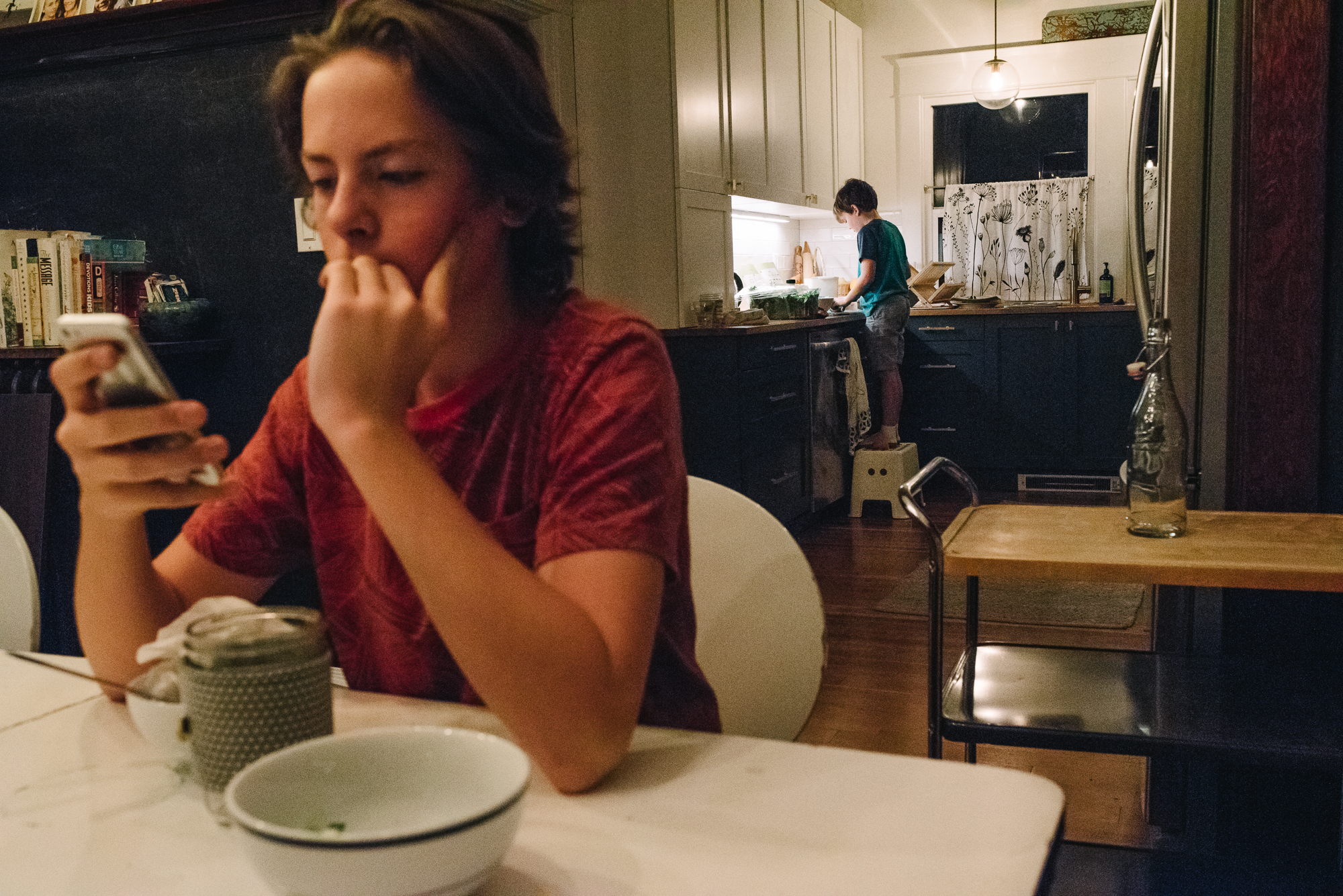 boy looking at phone - documentary family photography