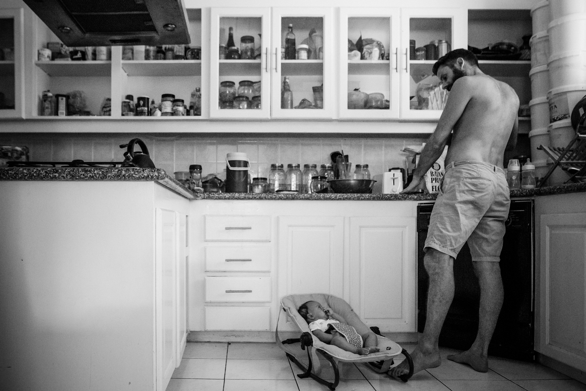 father with baby in bouncer - documentary family photography