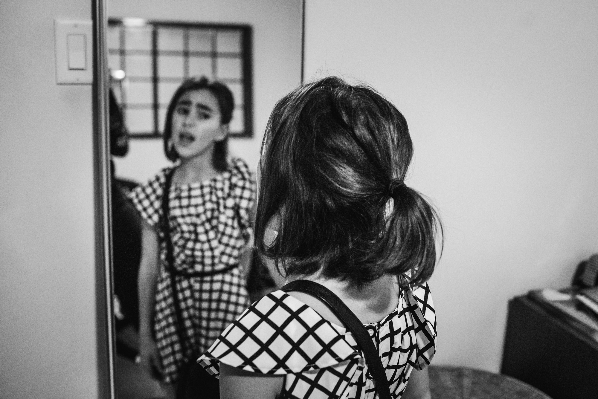 girl singing in mirror - documentary family photography