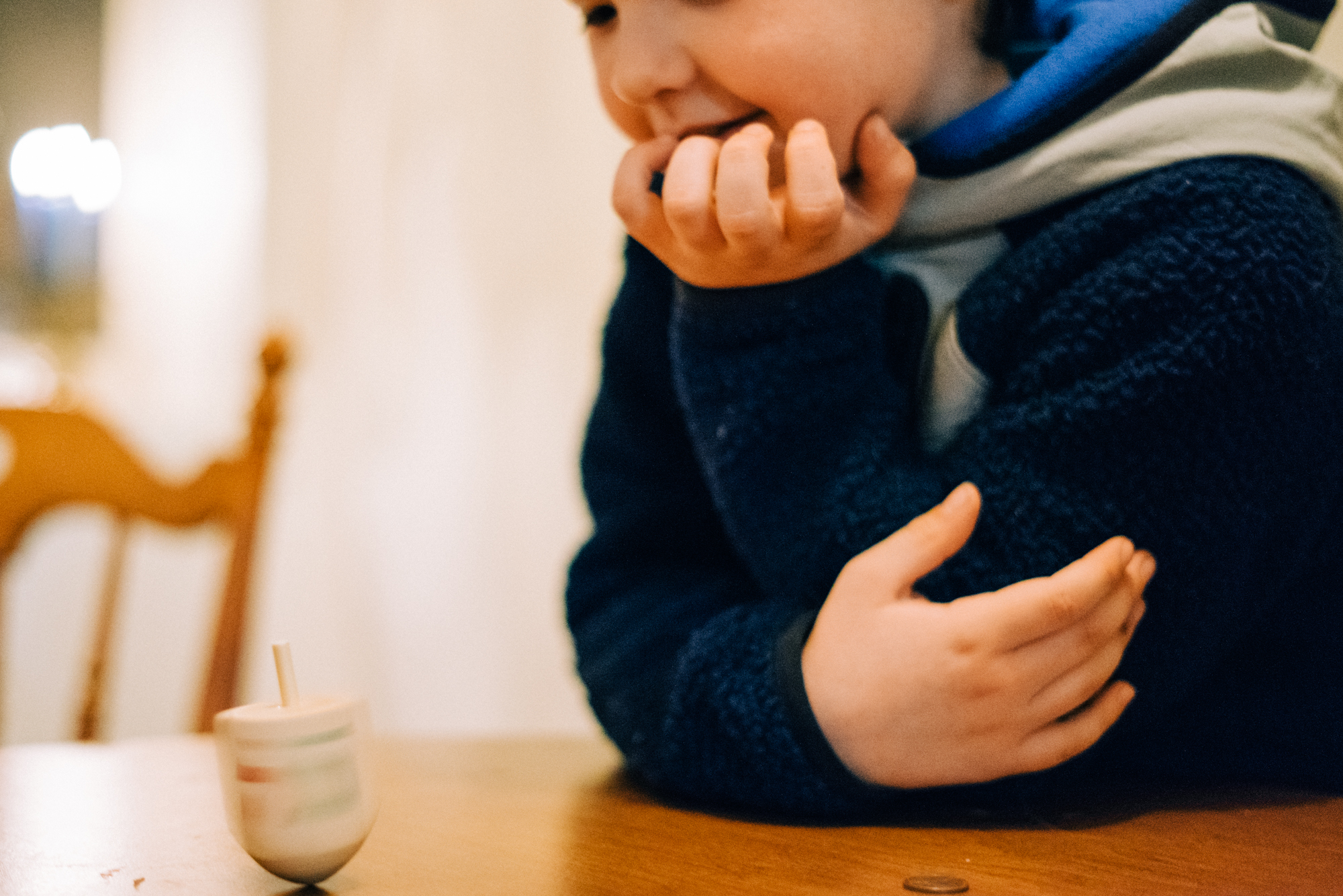 boy playing dreidel - documentary family photography