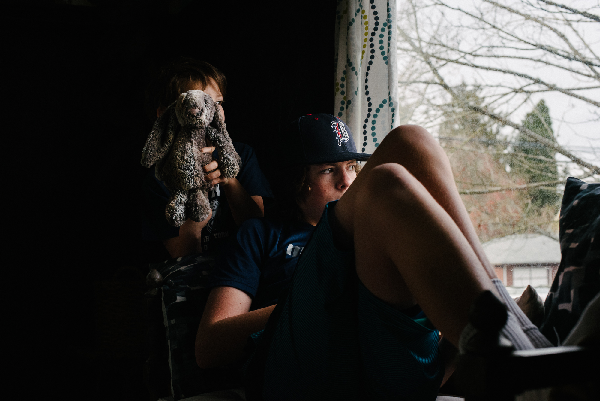 kid sitting in window - documentary family photography