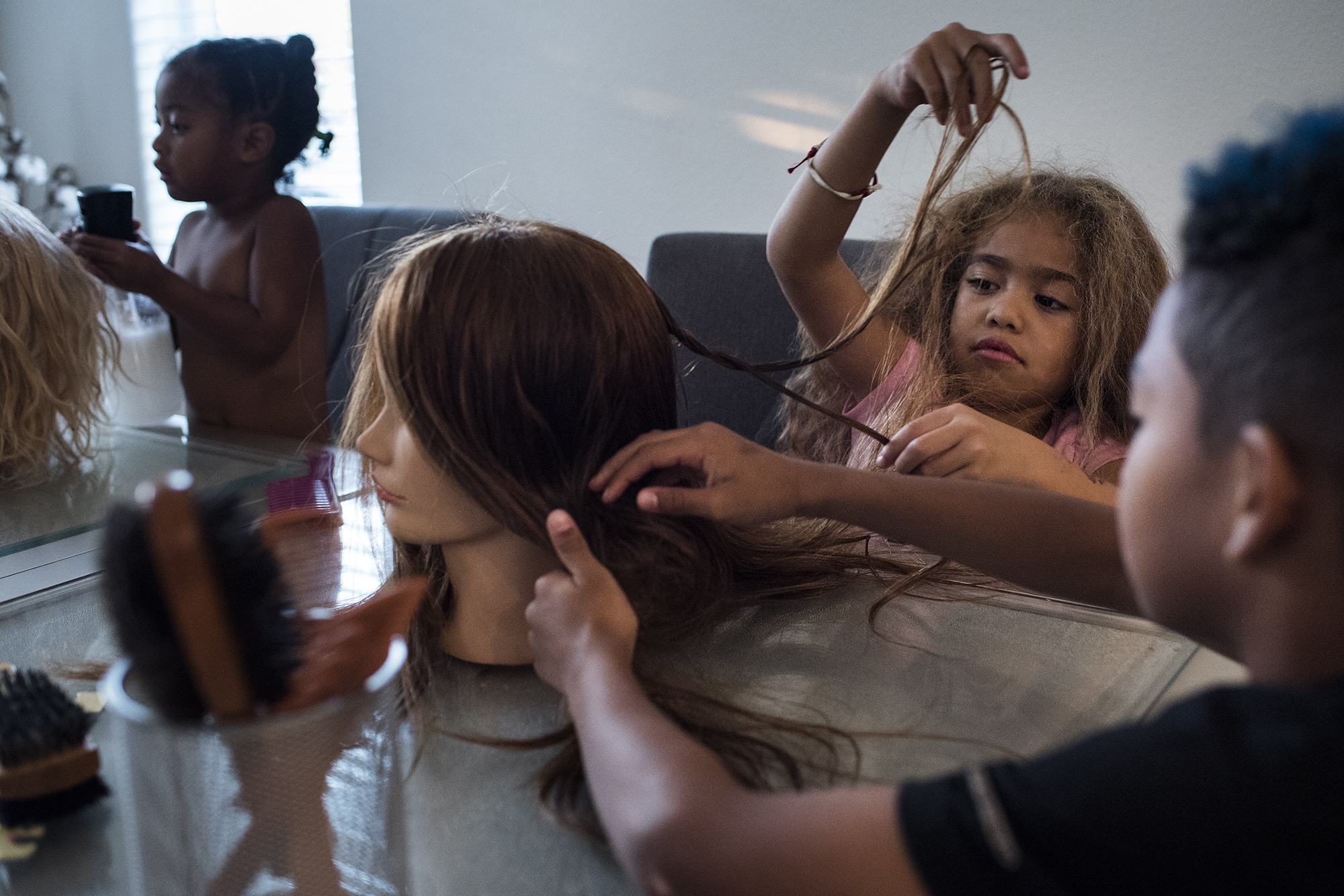 girls doing hair on wig - documentary family photography