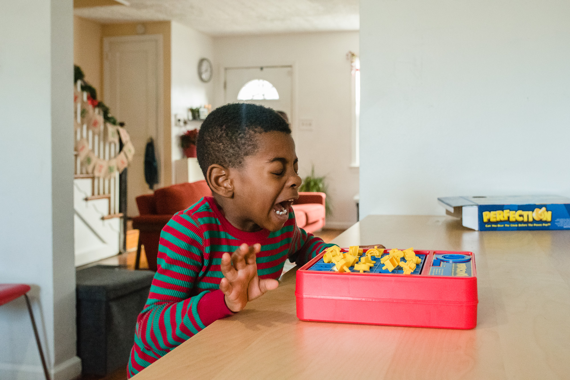 boy reacting to a game of concentration - documentary family photography