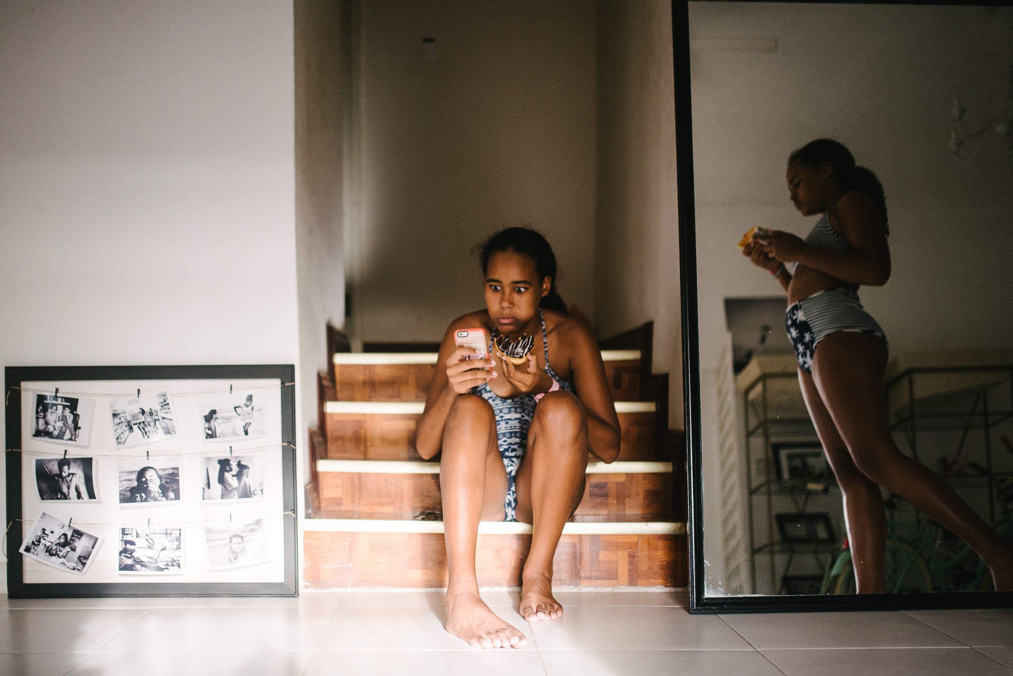 girl holding cell phone with wide eyed expression - documentary family photography