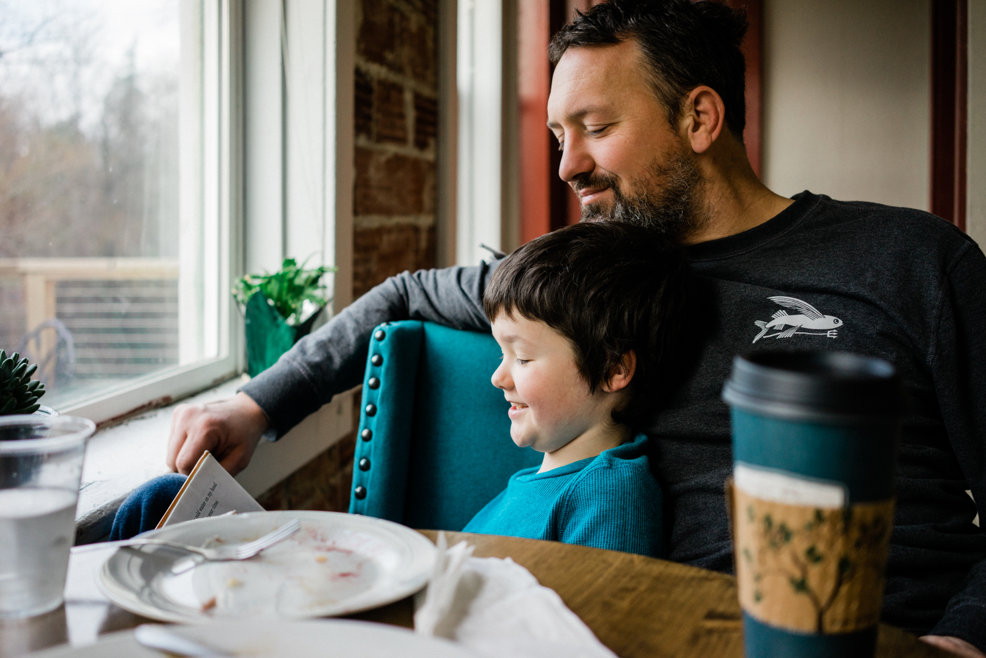 father and son read at coffeshop - documentary family photography