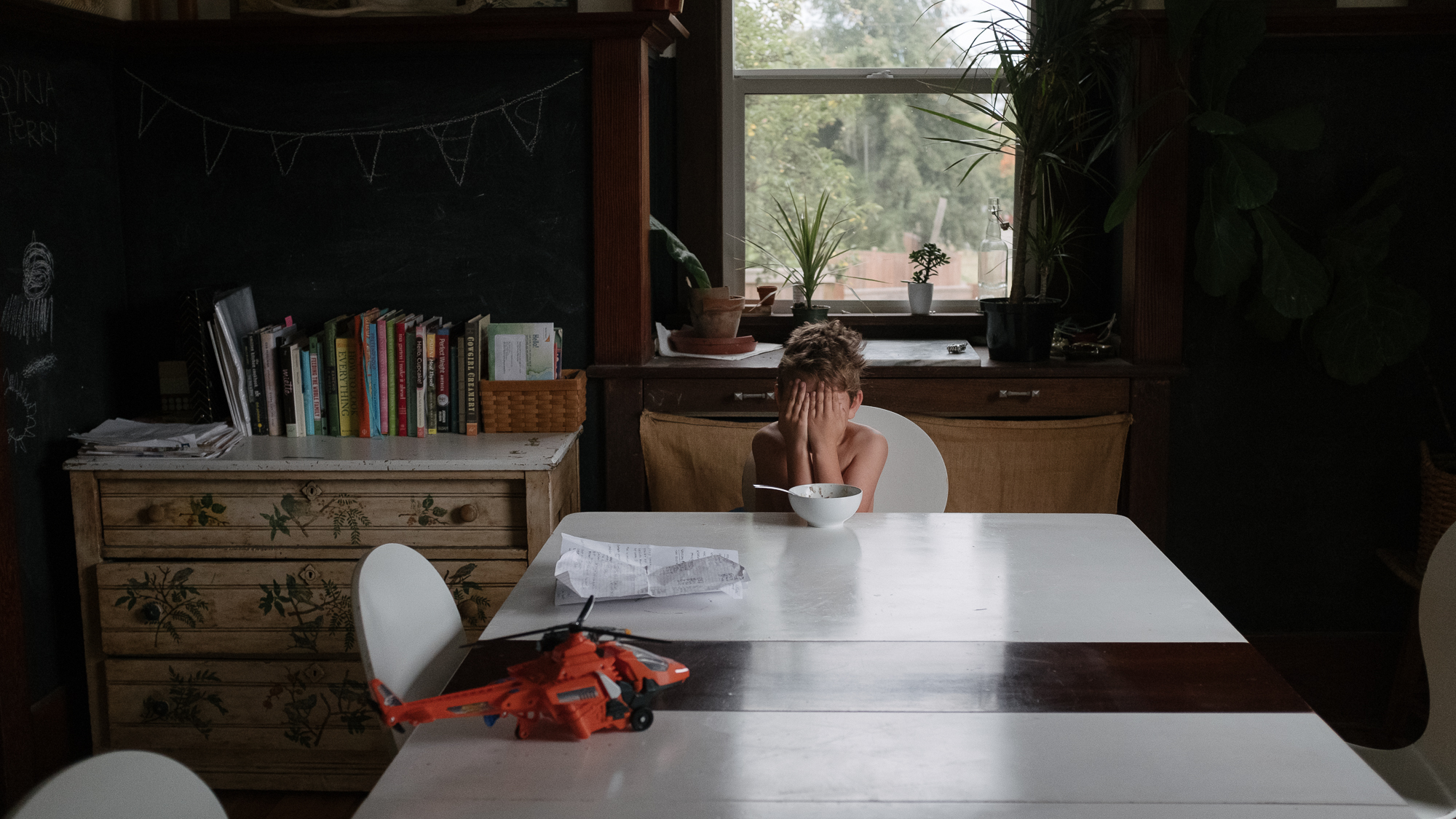 boy hiding behind hands - documentary family photography