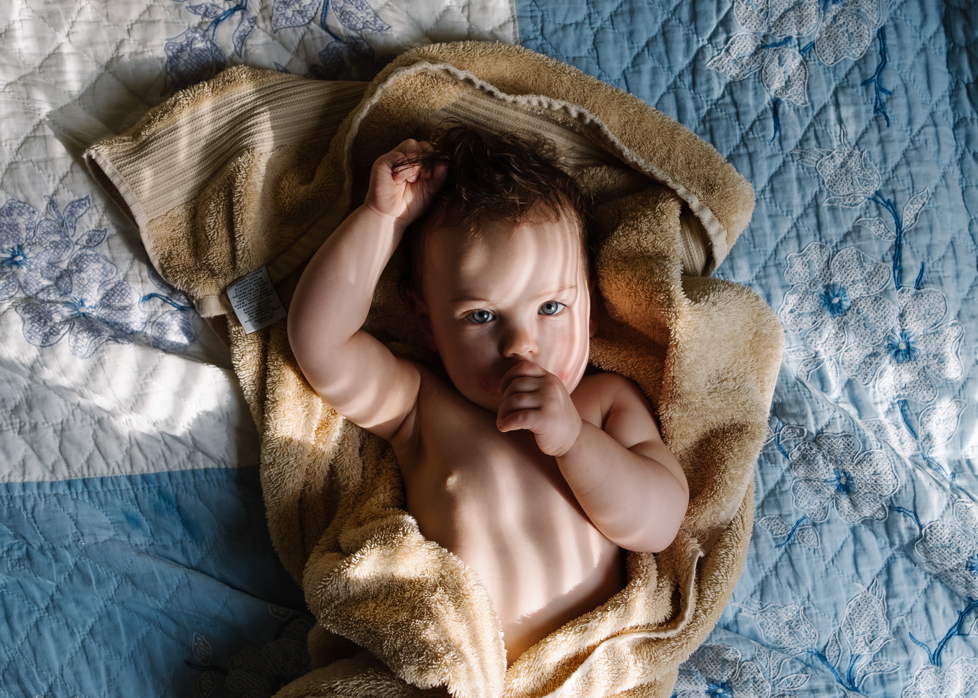 baby on bed in towel - Documentary Family photography
