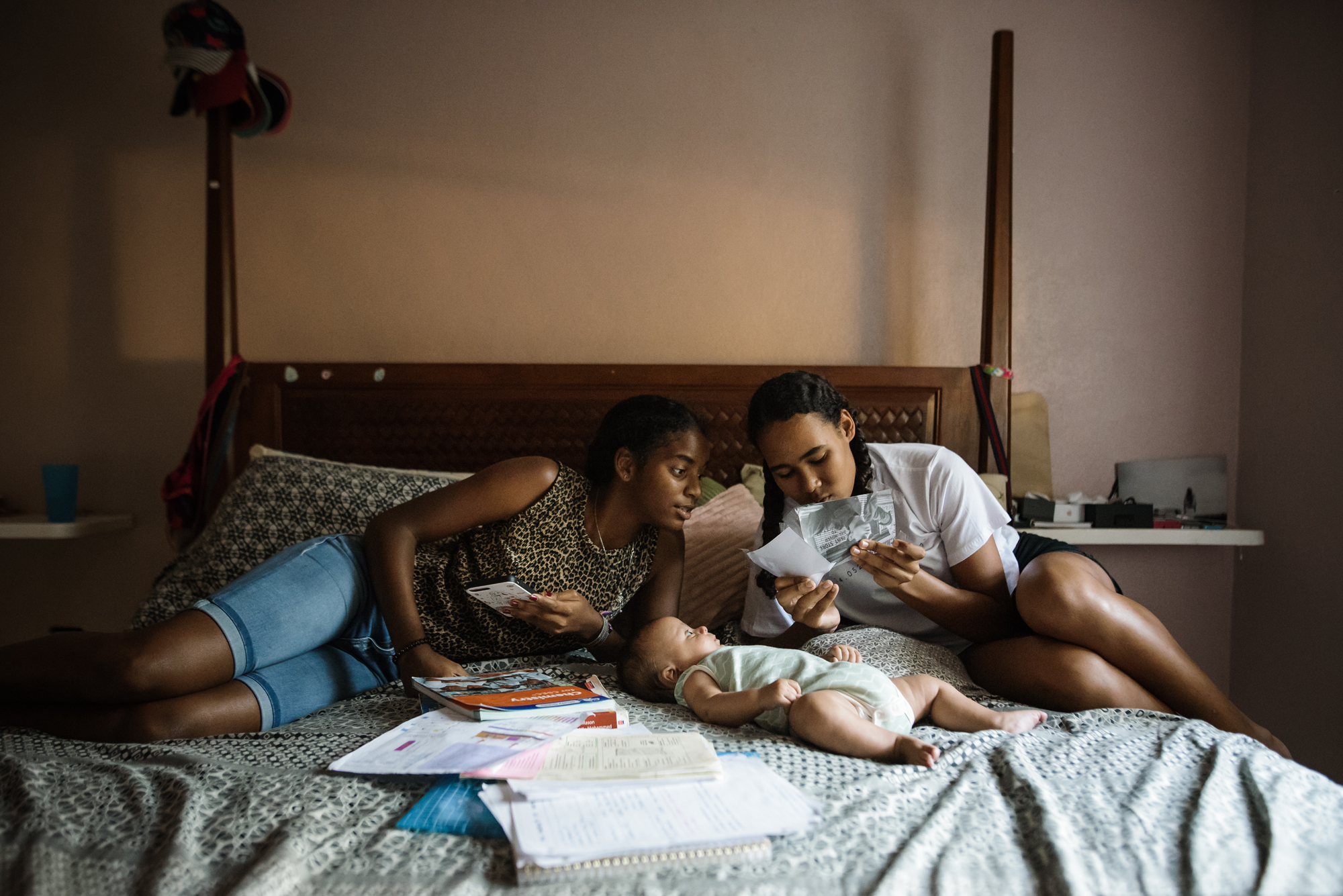 girls with baby on bed - documentary family photography