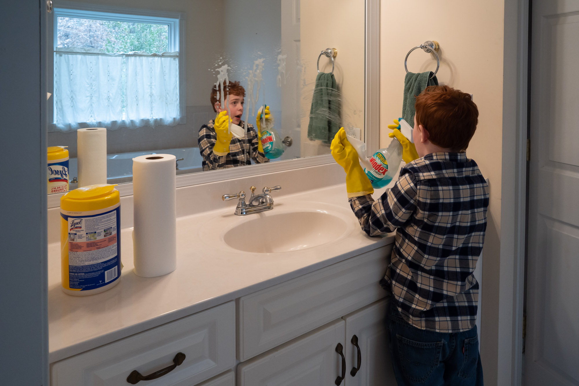 boy cleaning mirror - documentary family photography
