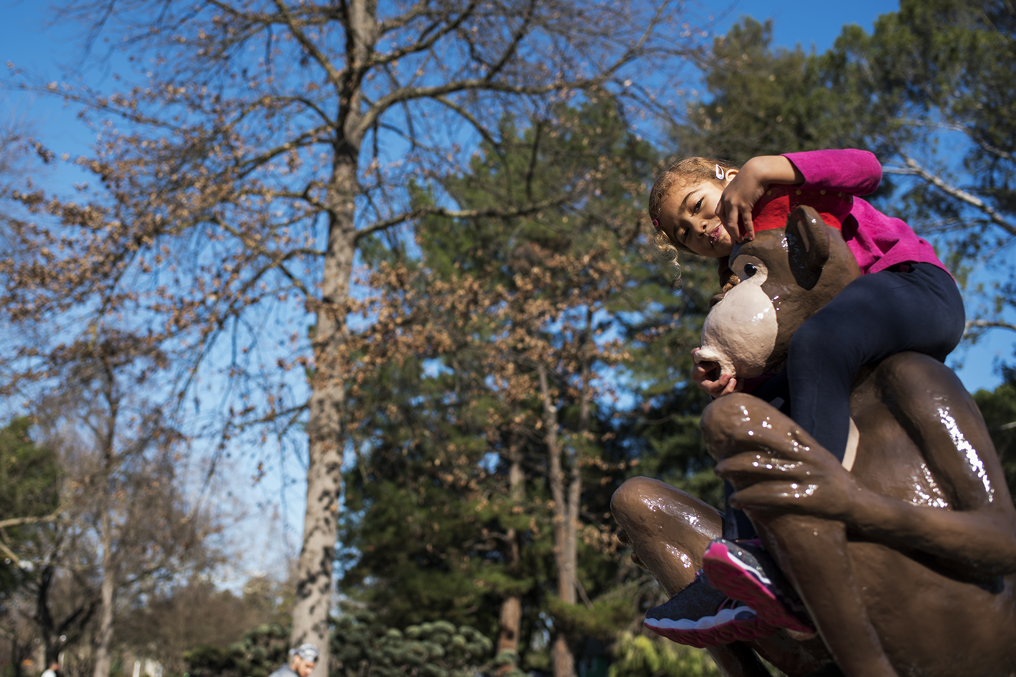 girl on monkey statue -documentary family photography