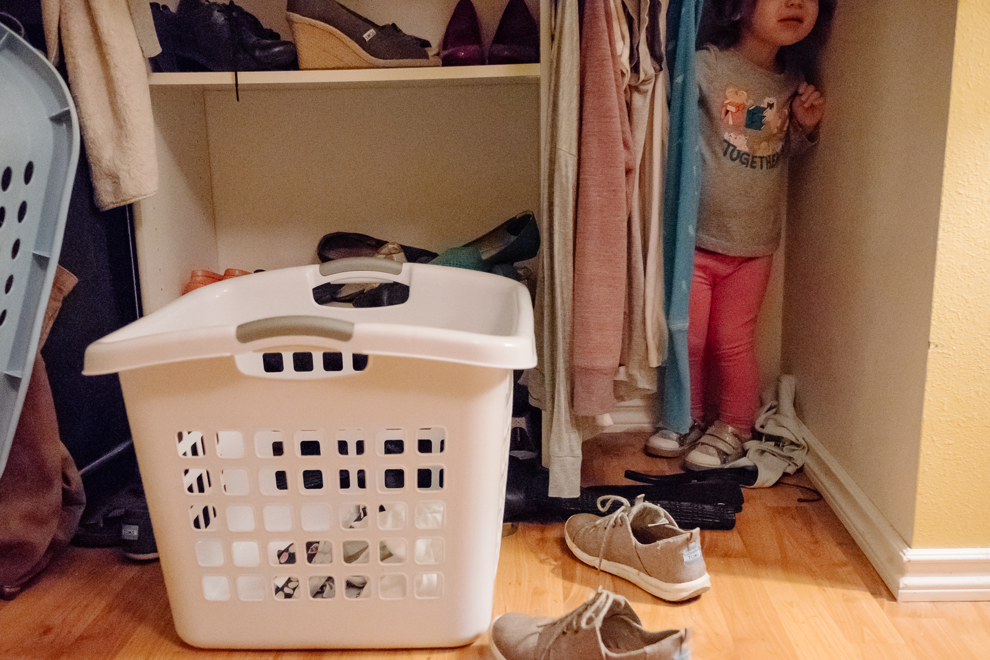 girl hiding in closet - documentary family photography
