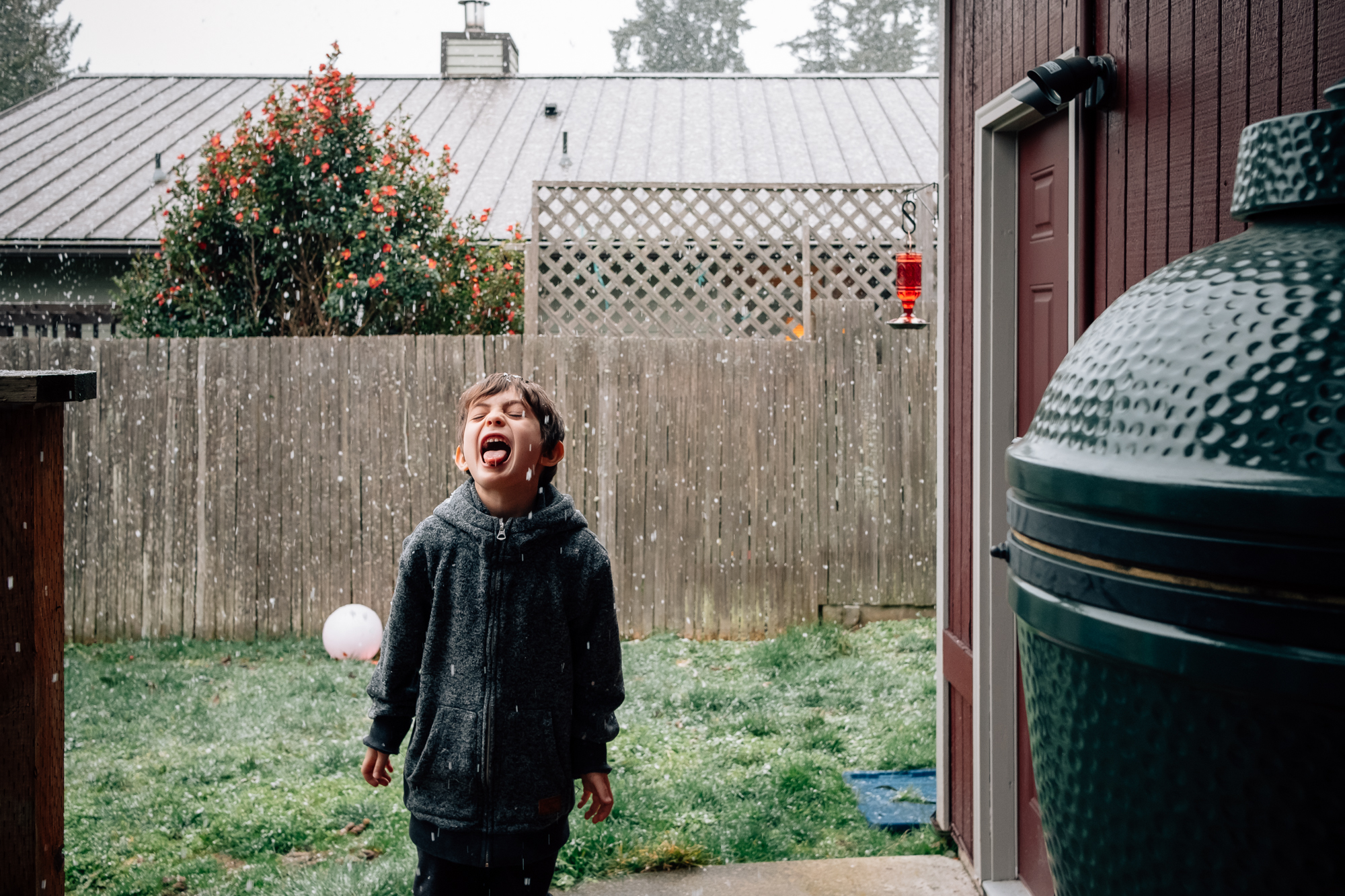 boy catching snowflakes on tongue - documentary family photography