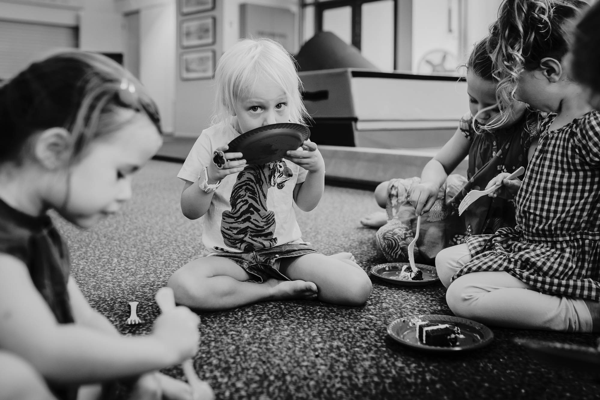 girl licking cake off plate - documentary family photography