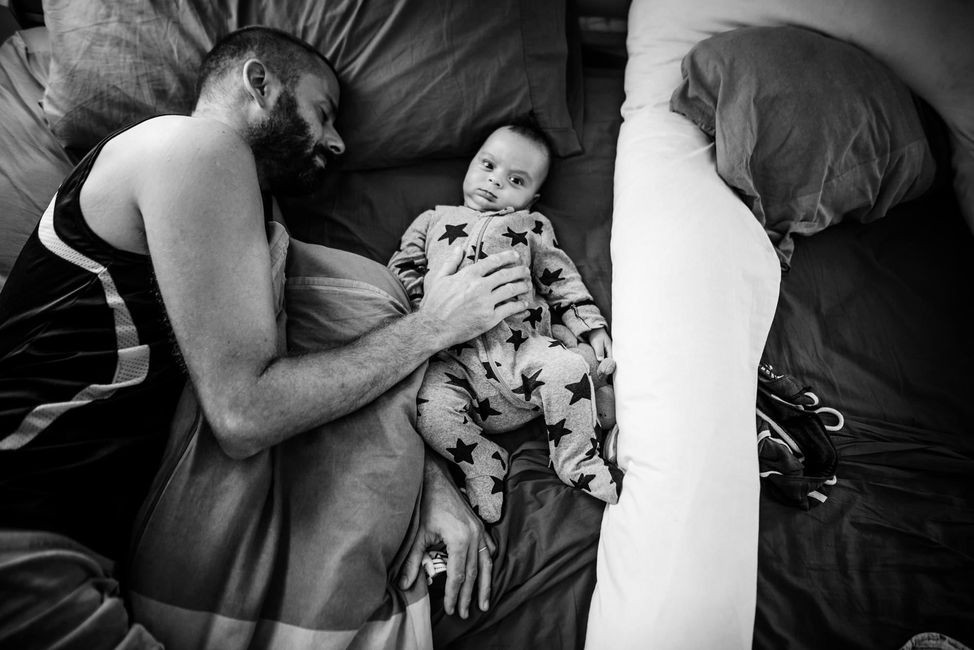 man on bed with baby - documentary family photography
