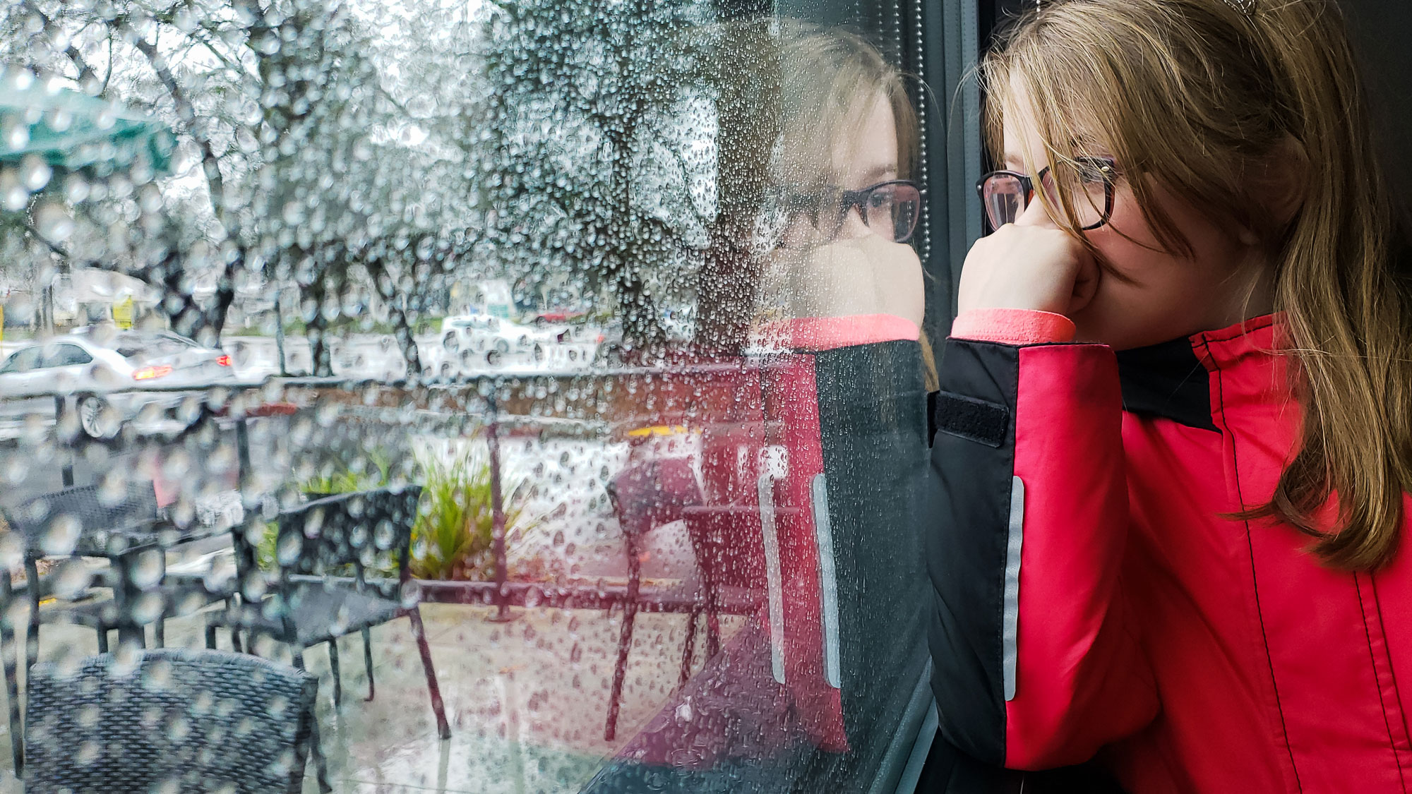 girl looks out window -documentary family photography