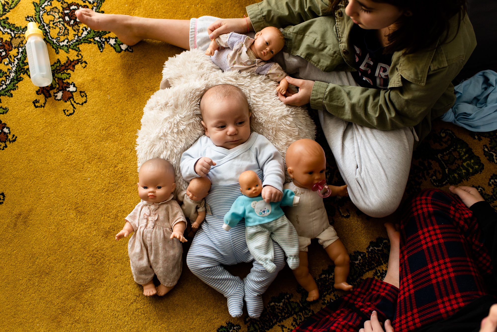 baby with baby dolls - documentary family photography