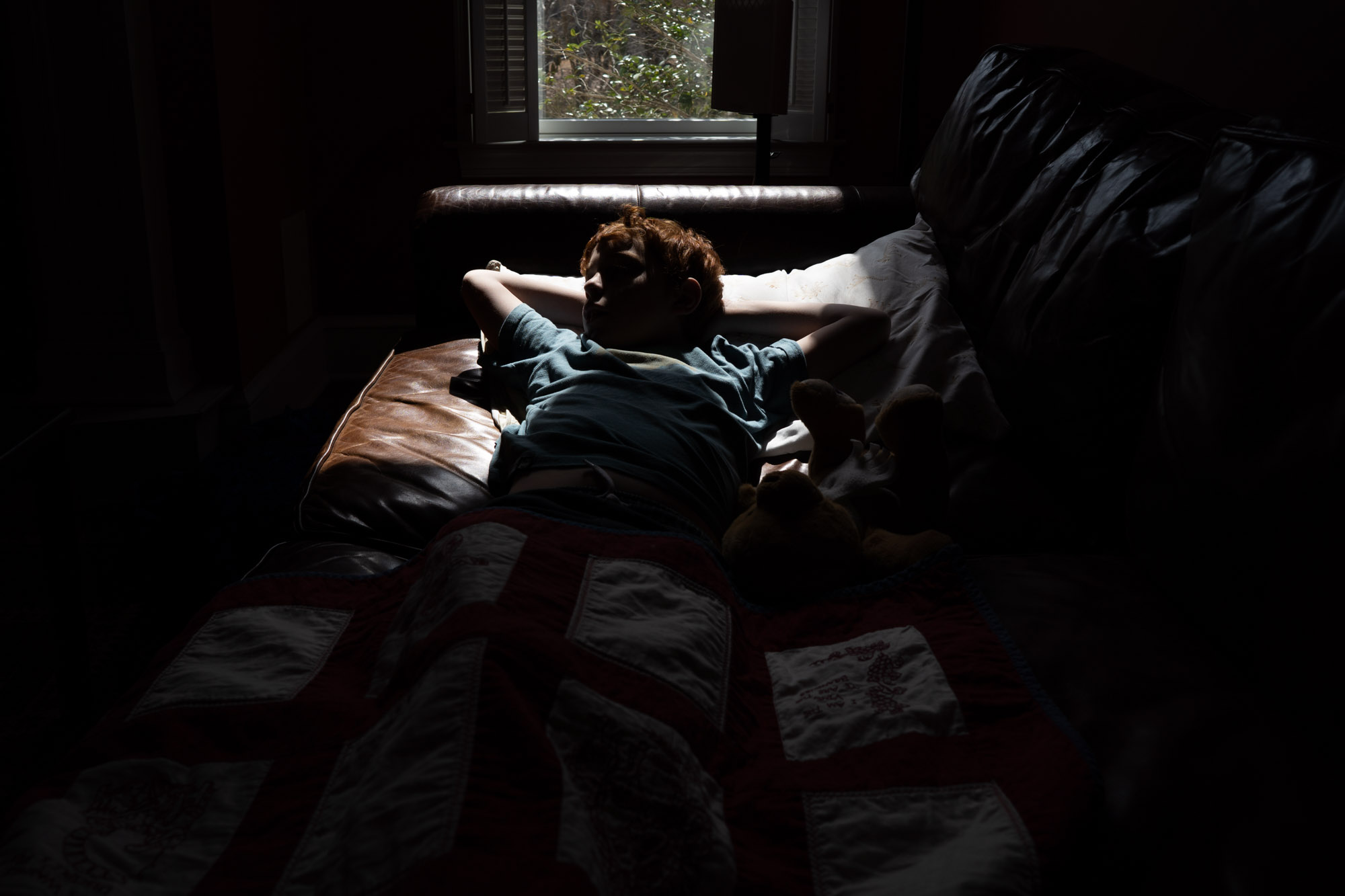 boy laying in sun spot -documentary family photography