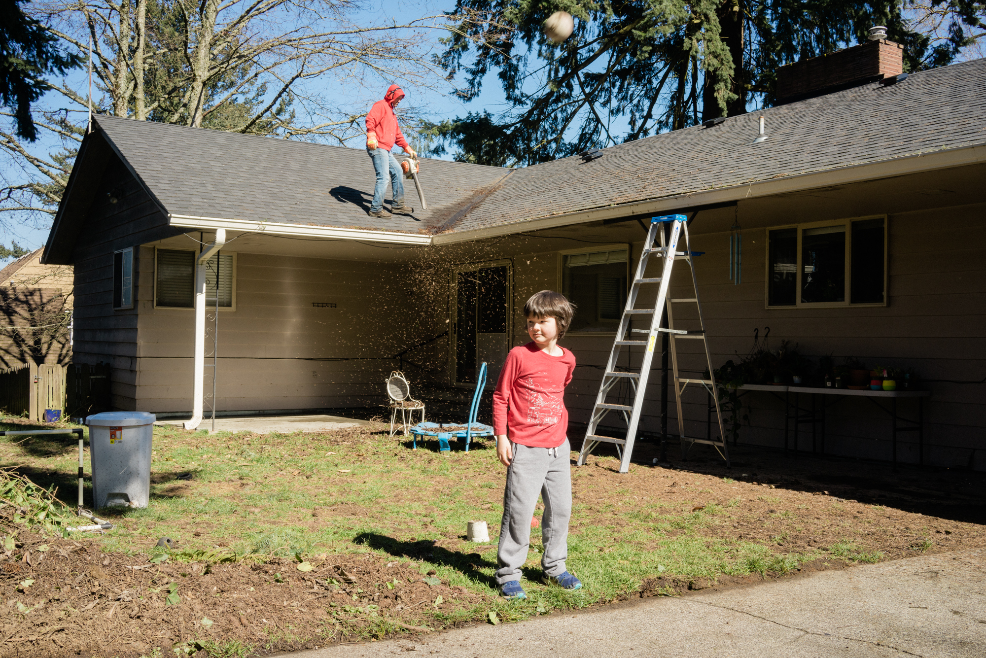 kid outside and man on roof - documentary family photography
