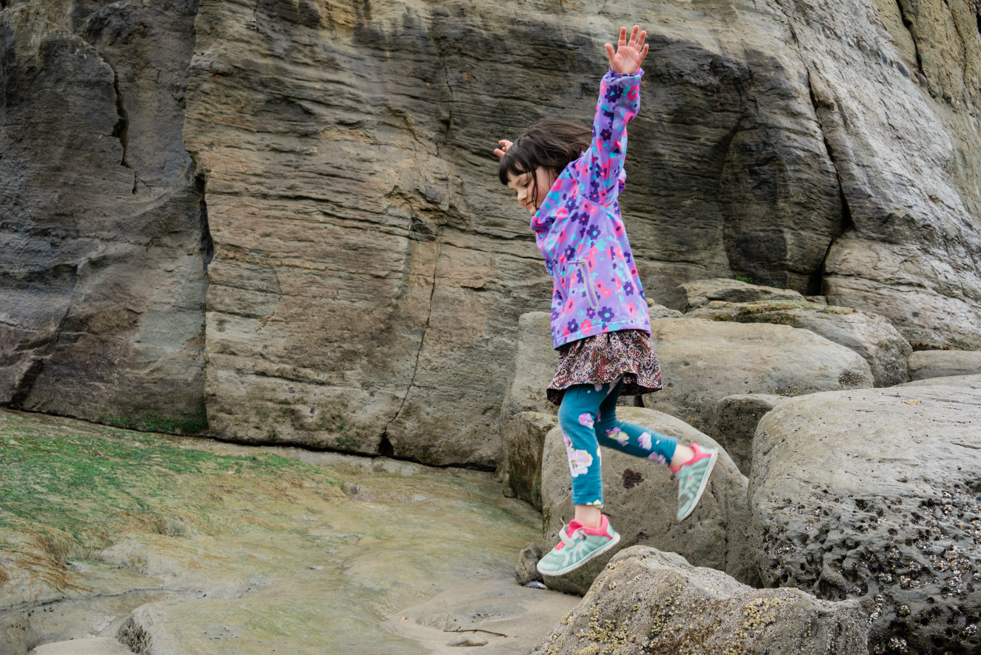 girl jumping on rocks - documentary family photography
