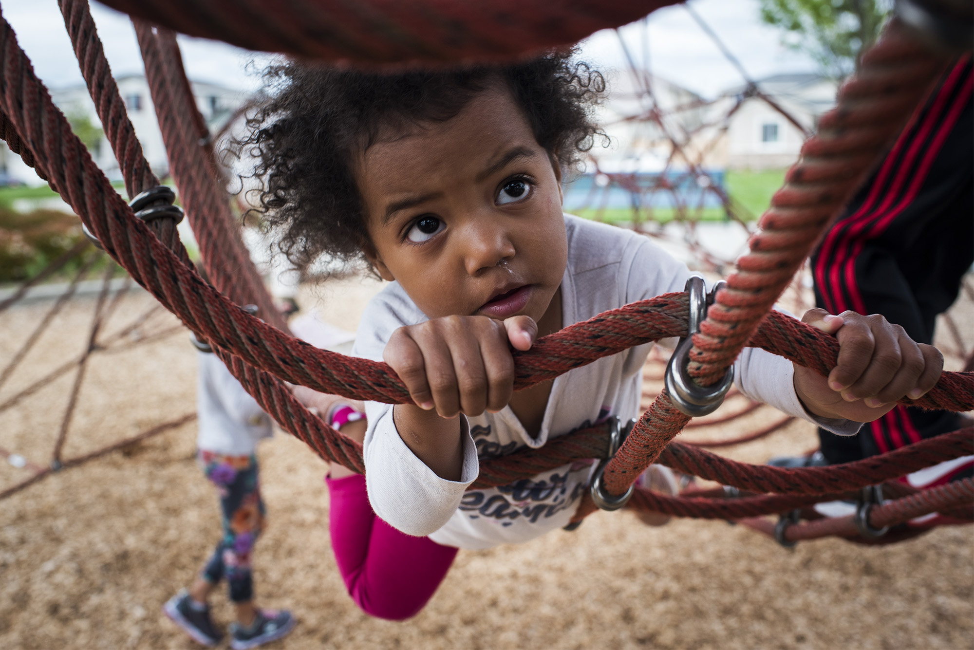 toddler girl climbing rope - documentary family photography