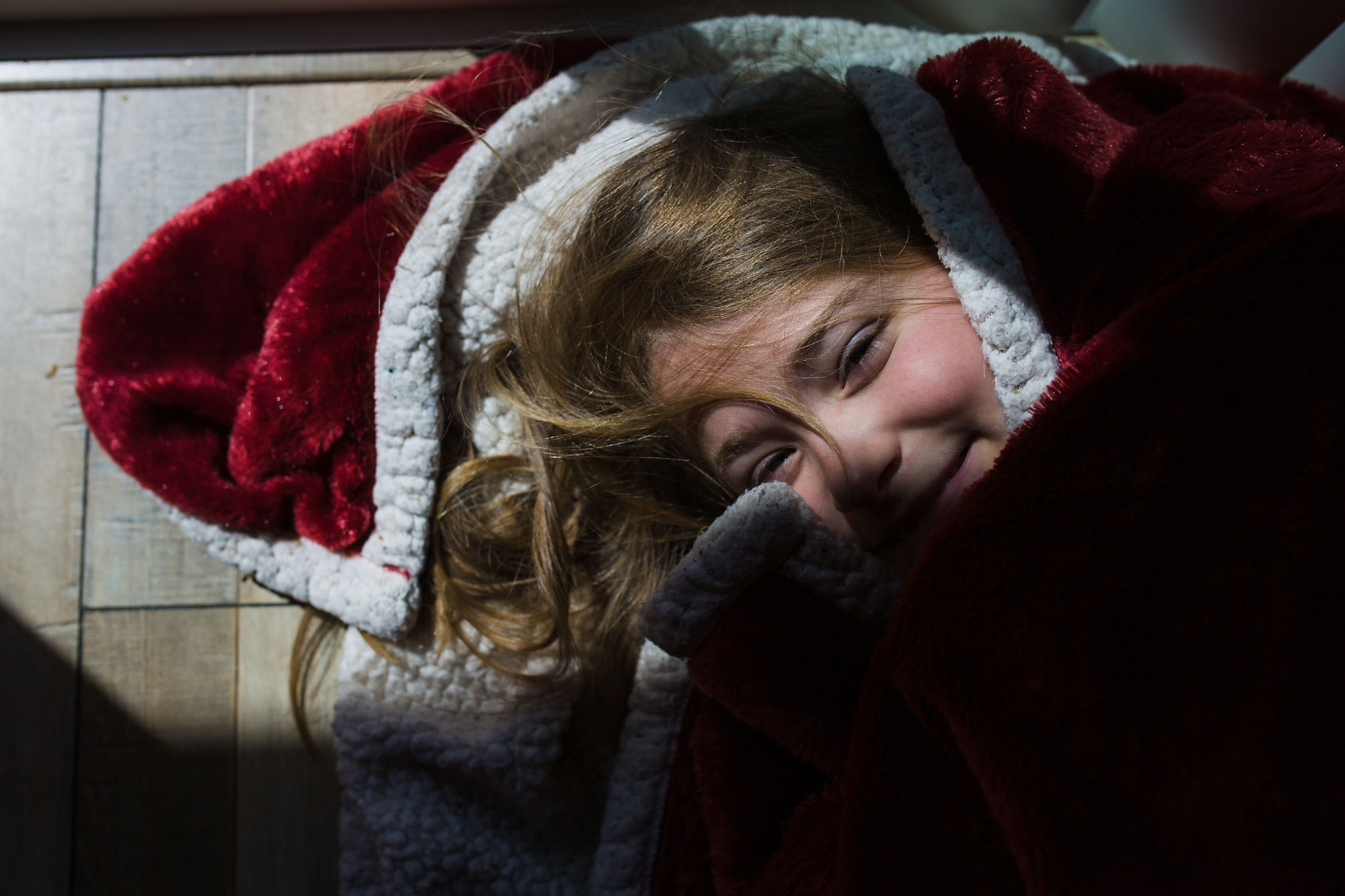 girl snuggled in blankets - documentary family photography