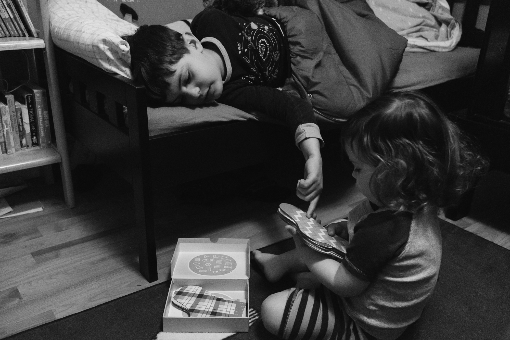 brother helps sister with flash cards - documentary family photography