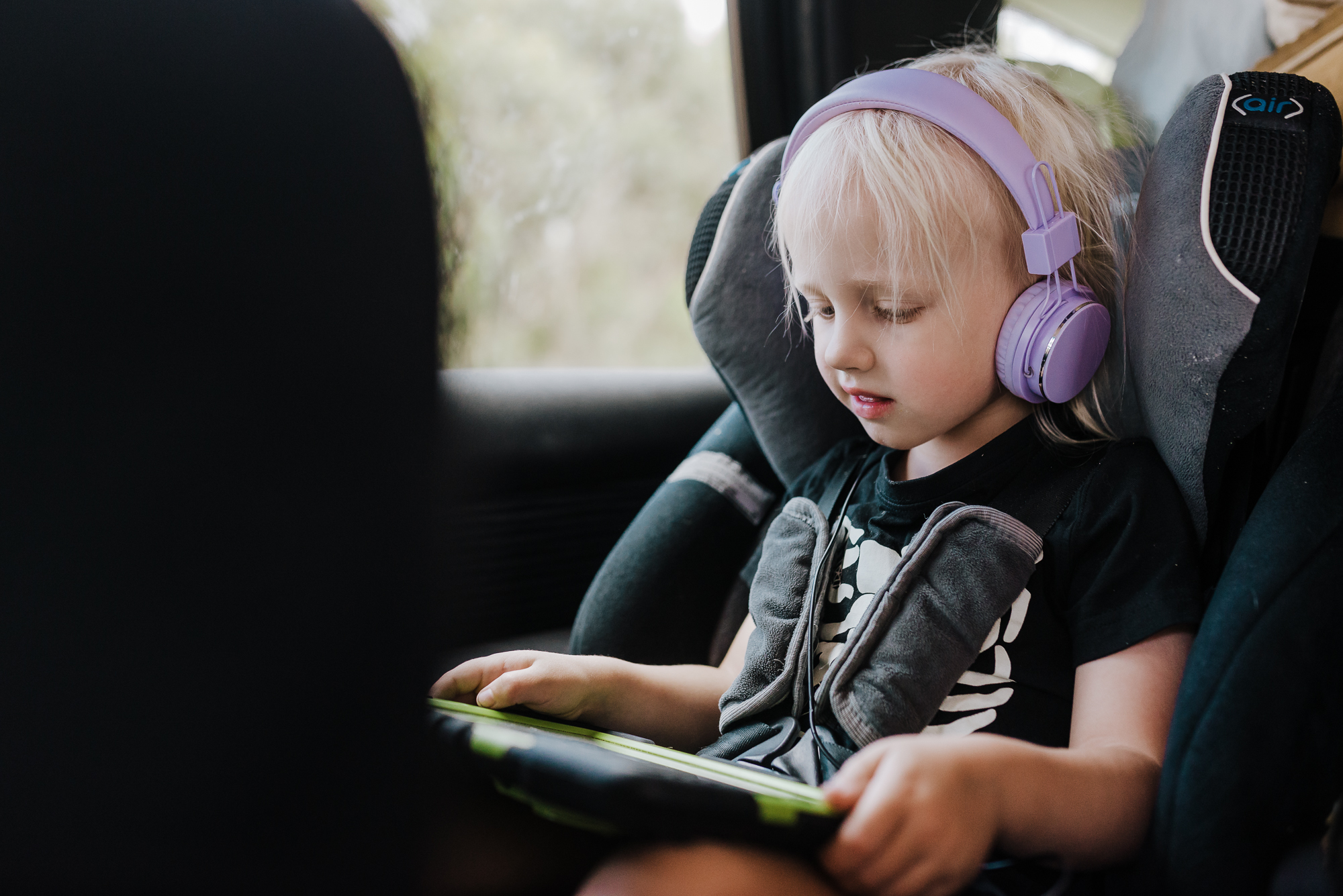 kid with tablet in car - documentary family photography